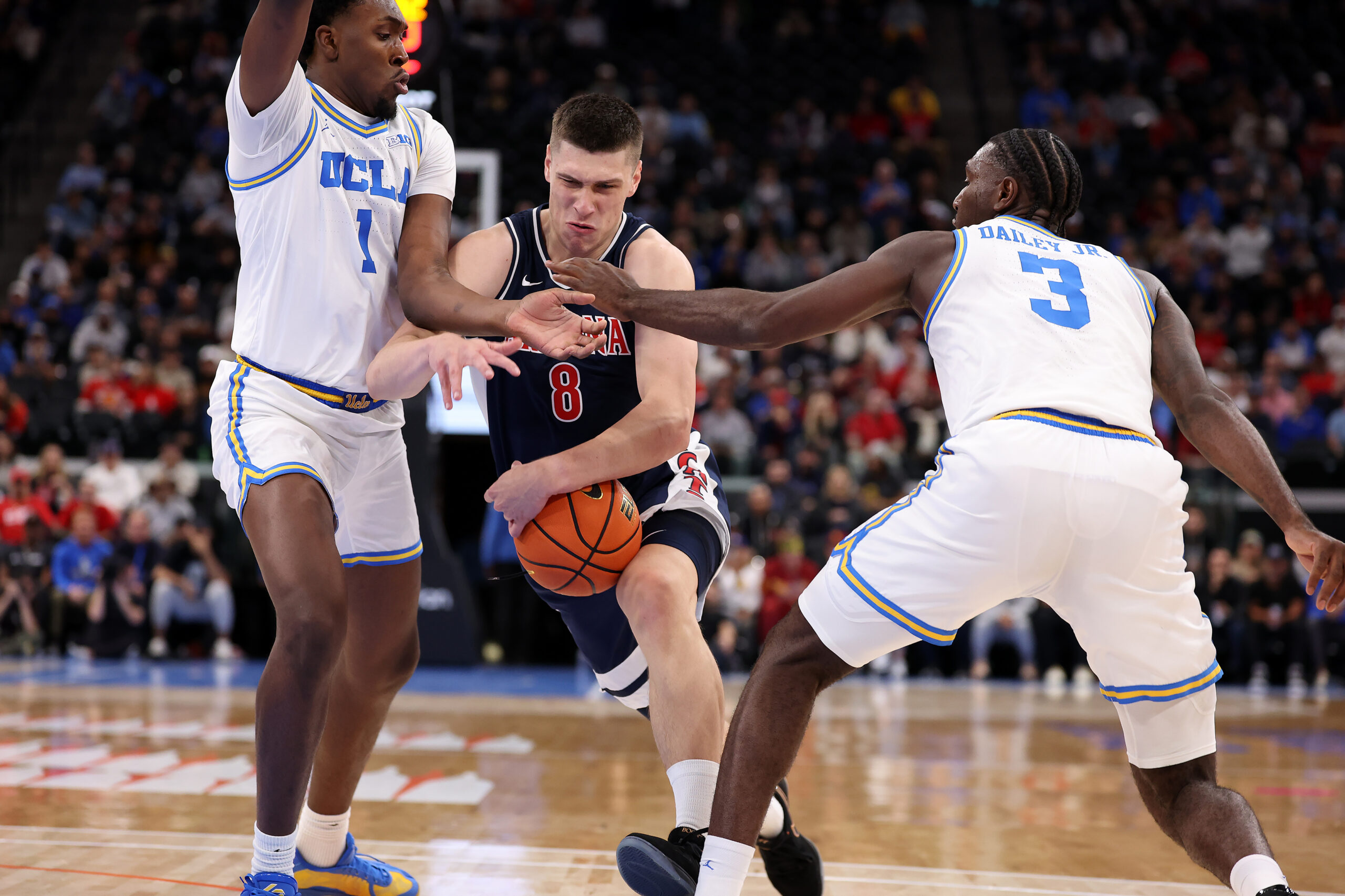 Nov 14, 2025; Inglewood, California, USA;  Arizona Wildcats forward Ivan Kharchenkov (8) drives between UCLA Bruins center Xavier Booker (1) and forward Eric Dailey Jr. (3) during the first half of the Hall of Fame Series game at Intuit Dome. Mandatory Credit: Kiyoshi Mio-Imagn Images