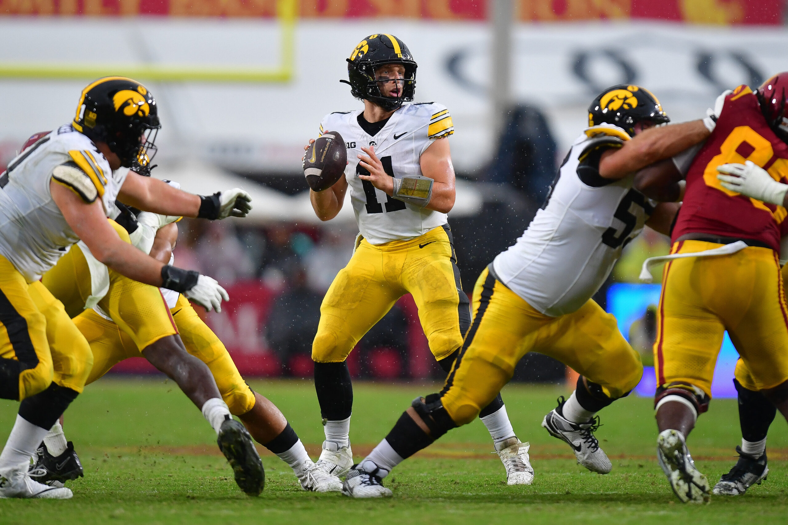 Nov 15, 2025; Los Angeles, California, USA; Iowa Hawkeyes quarterback Mark Gronowski (11) drops back to pass against the Southern California Trojans during the second half at the Los Angeles Memorial Coliseum. Mandatory Credit: Gary A. Vasquez-Imagn Images