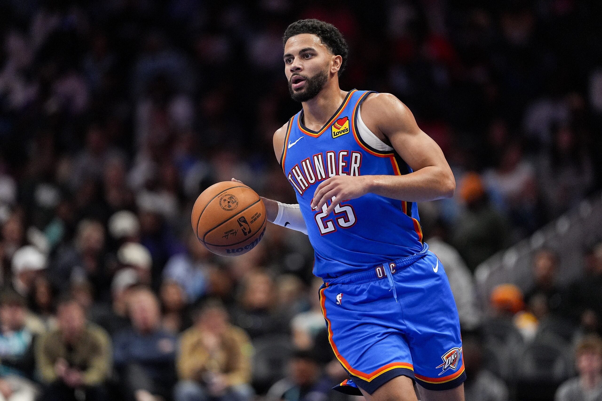 Nov 15, 2025; Charlotte, North Carolina, USA; Oklahoma City Thunder guard Ajay Mitchell (25) brings the ball up court against the Charlotte Hornets during the second half at Spectrum Center. Mandatory Credit: Jim Dedmon-Imagn Images