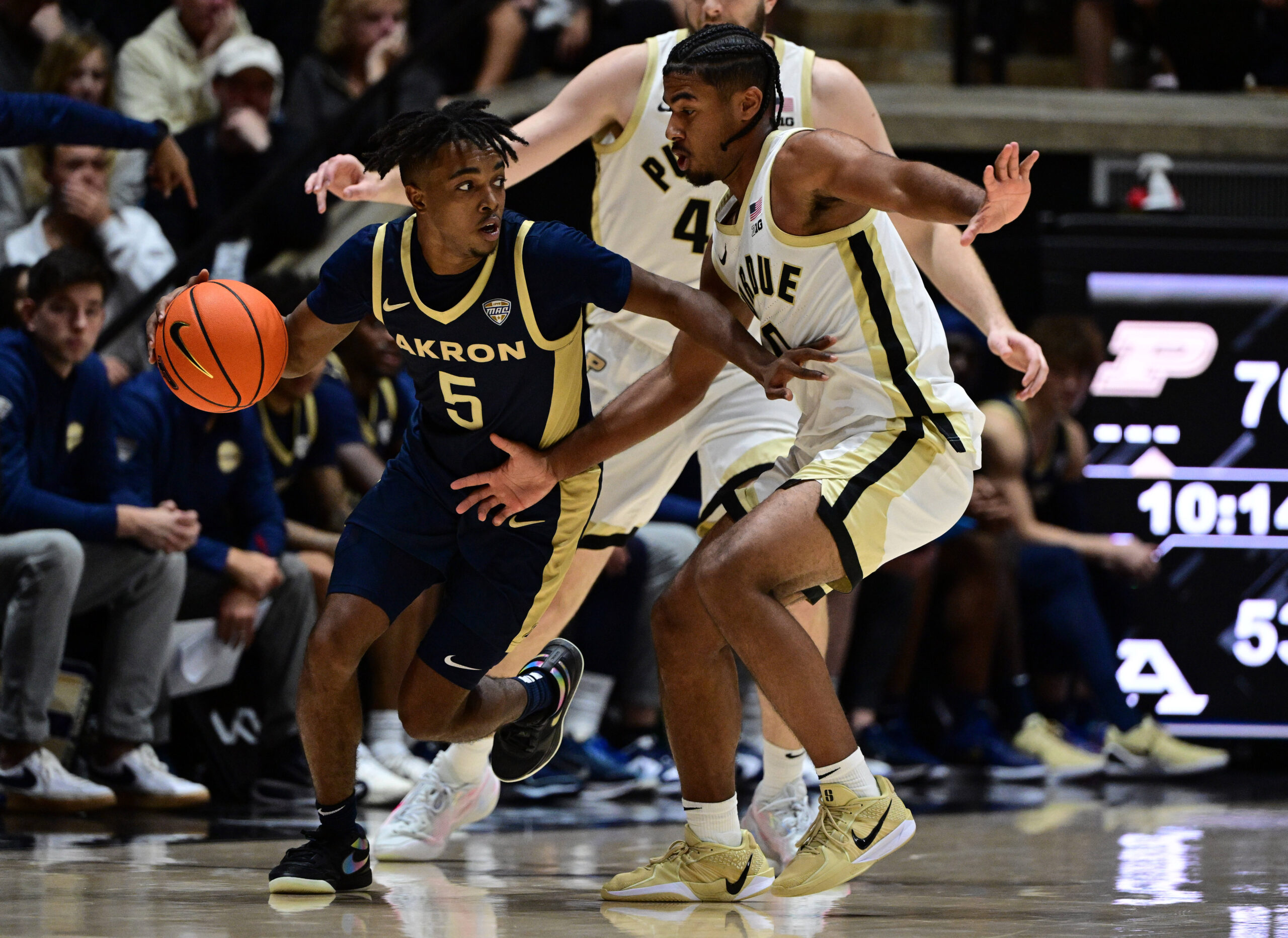 Nov 16, 2025; West Lafayette, Indiana, USA; Akron Zips guard Tavari Johnson (5) drives past Purdue Boilermakers guard C.J. Cox (0) during the second half at Mackey Arena. Mandatory Credit: Marc Lebryk-Imagn Images