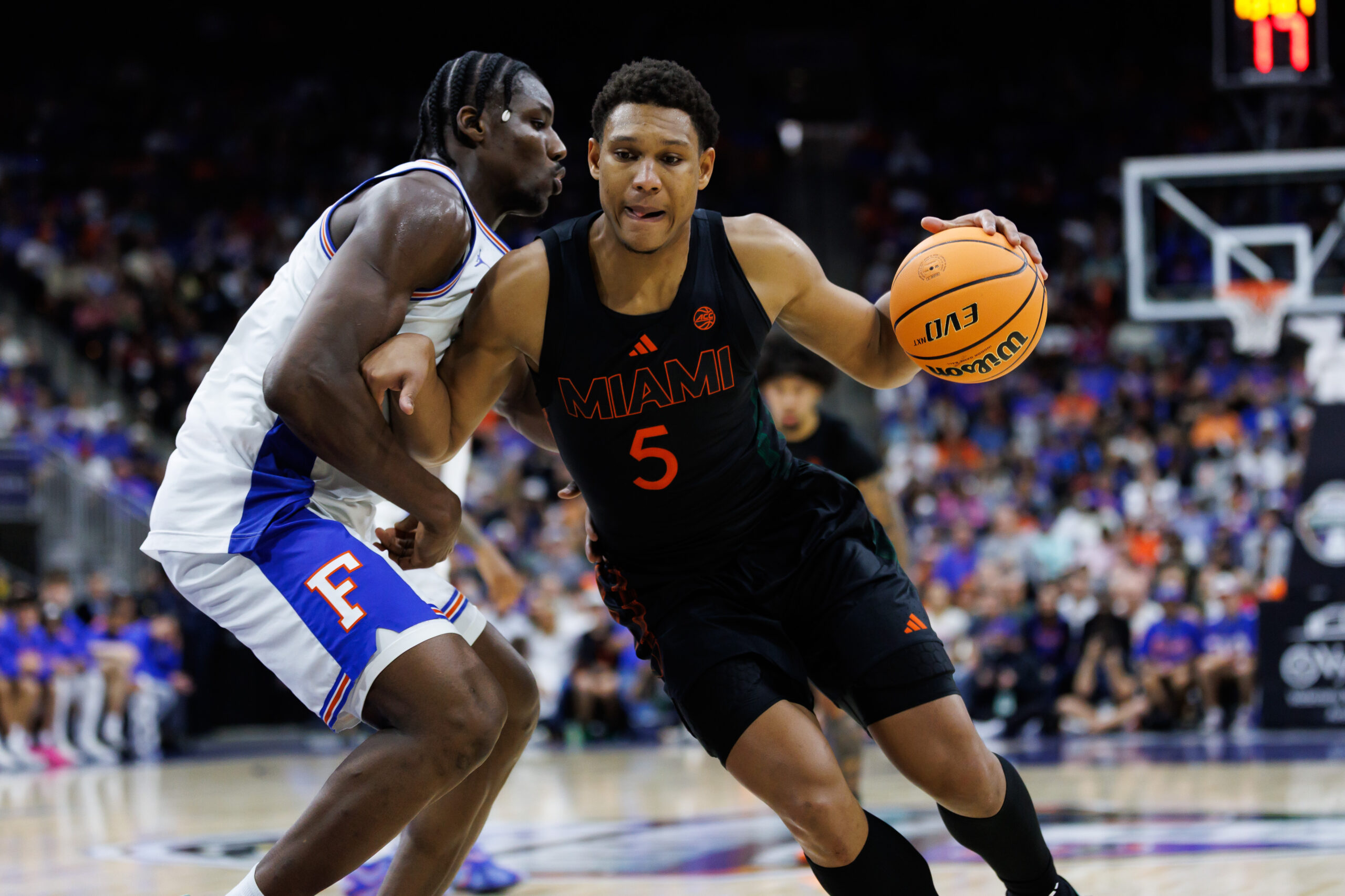Nov 16, 2025; Jacksonville, Florida, USA; Miami Hurricanes forward Malik Reneau (5) drives to the basket at Florida Gators center Rueben Chinyelu (9) during the second half at VyStar Veterans Memorial Arena. Mandatory Credit: Matt Pendleton-Imagn Images