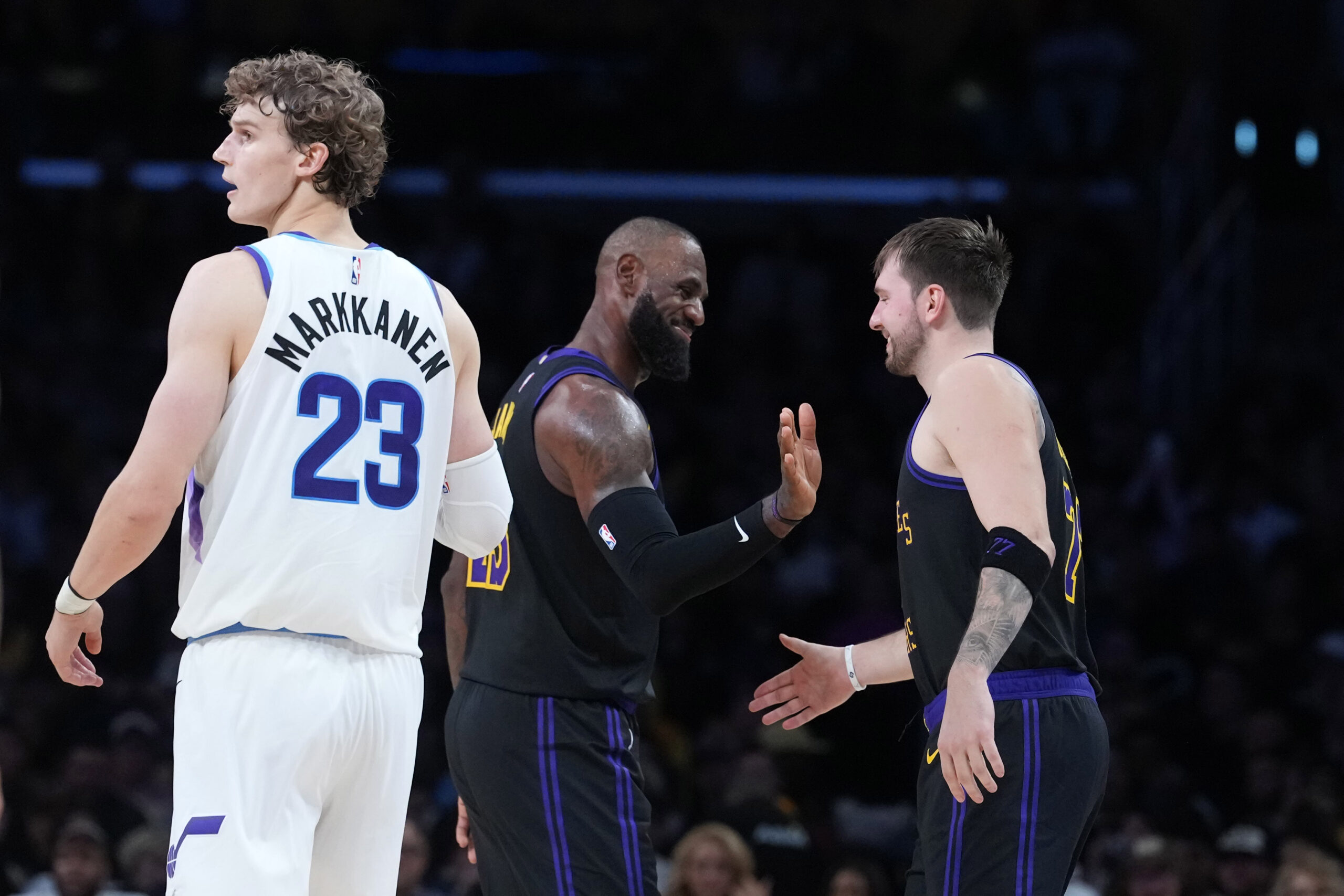 Nov 18, 2025; Los Angeles, California, USA; Los Angeles Lakers forward LeBron James (center) and guard Luka Doncic (77) react as Utah Jazz forward Lauri Markkanen (23) watches in the fourth quarter at Crypto.com Arena. Mandatory Credit: Kirby Lee-Imagn Images