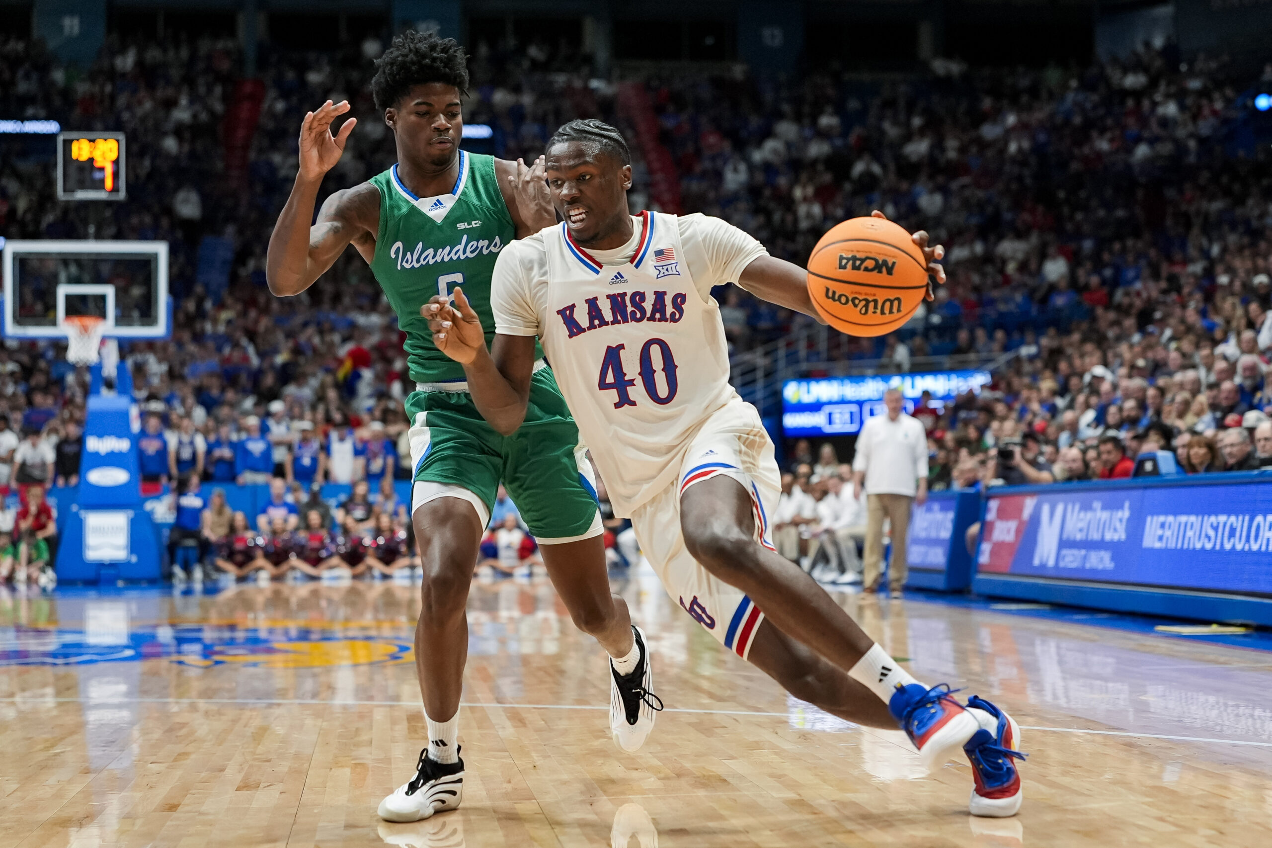 Nov 11, 2025; Lawrence, Kansas, USA; Kansas Jayhawks forward Flory Bidunga (40) drives against Texas A&M-Corpus Christi Islanders forward Kobi Pearson (5) during the second half at Allen Fieldhouse. Mandatory Credit: Jay Biggerstaff-Imagn Images