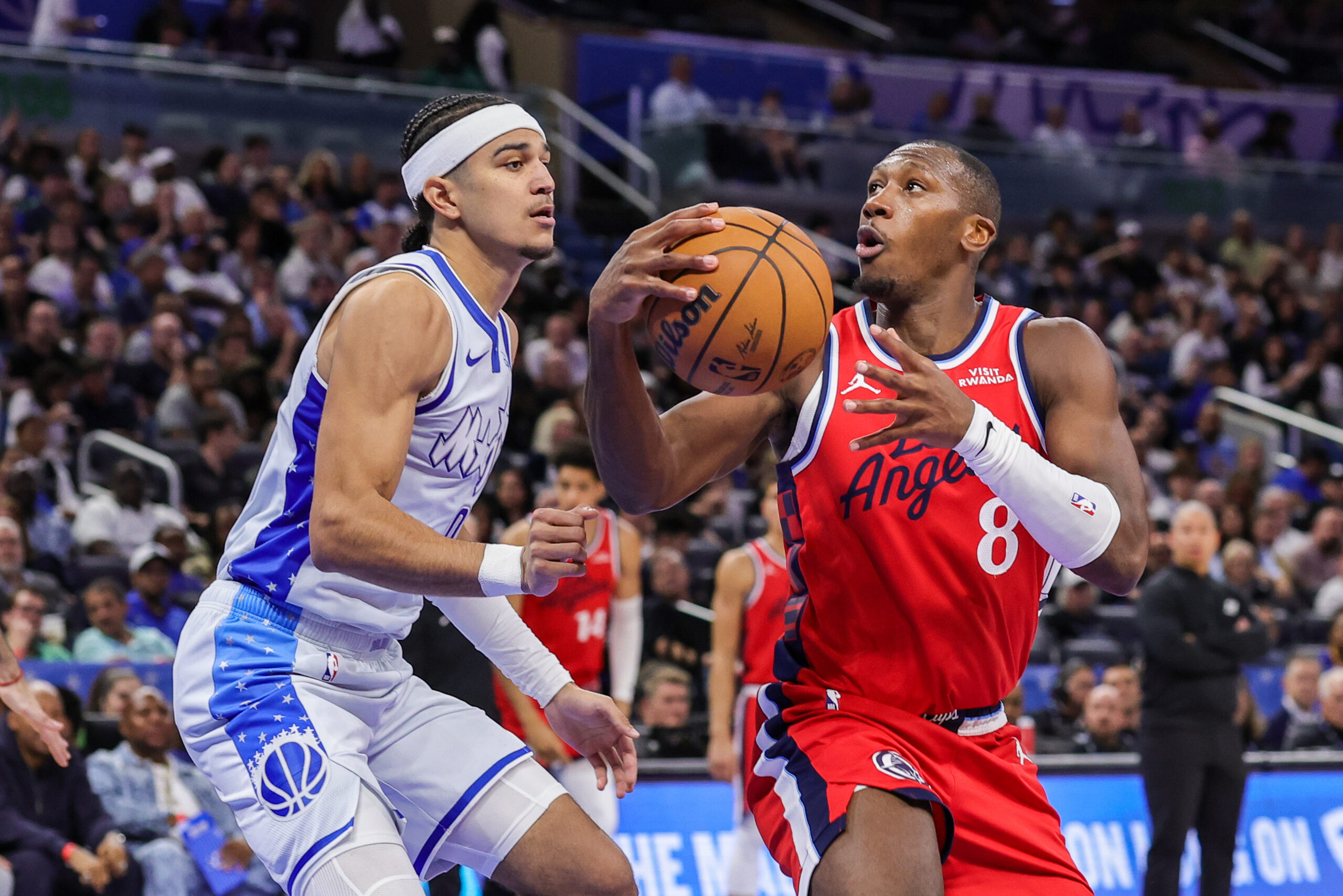 Nov 20, 2025; Orlando, Florida, USA; LA Clippers guard Kris Dunn (8) controls the ball in front of Orlando Magic guard Anthony Black (0) during the second half at Kia Center. Mandatory Credit: Mike Watters-Imagn Images