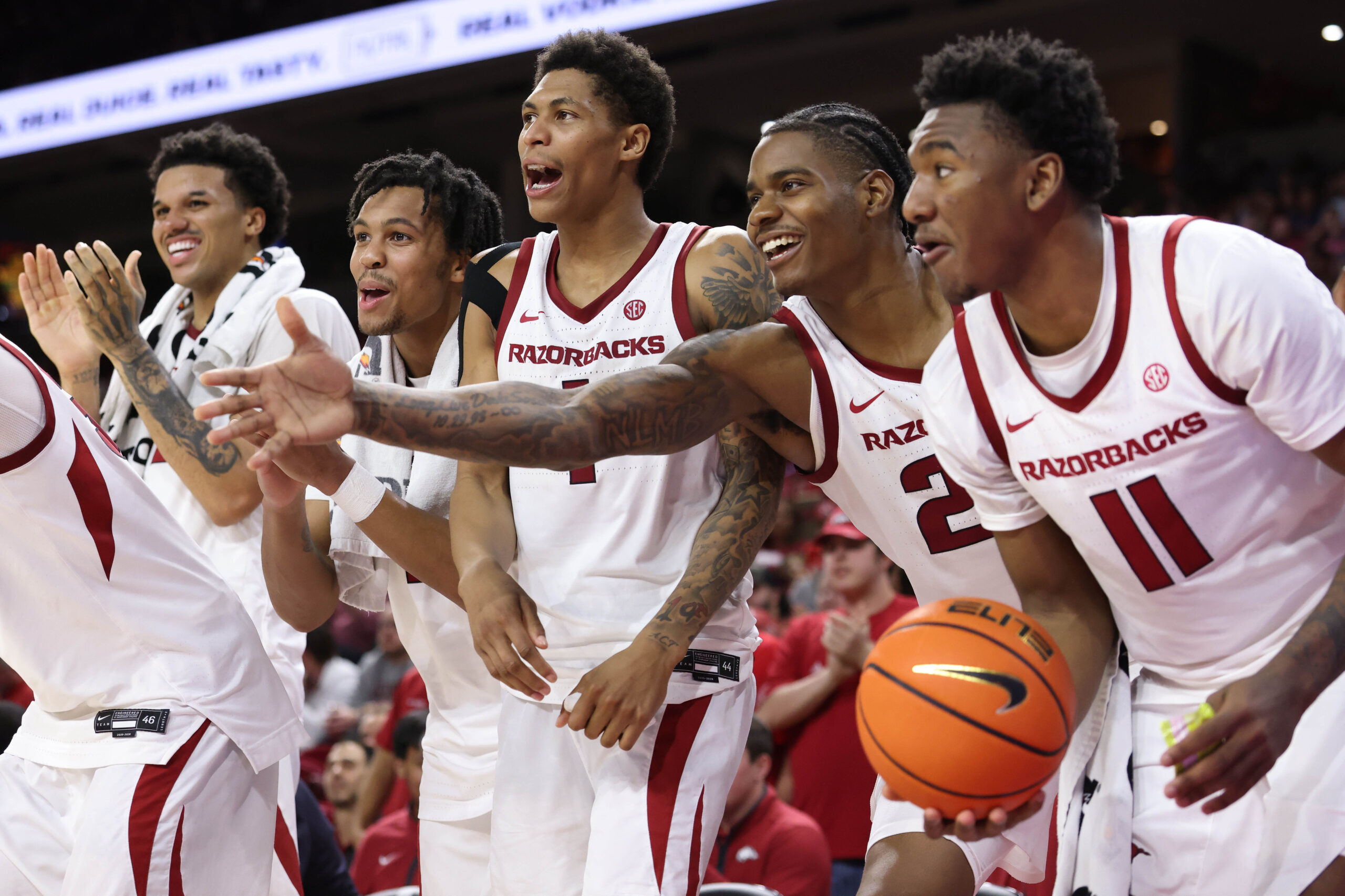Nov 21, 2025; Fayetteville, Arkansas, USA; Arkansas Razorbacks forward Malique Ewin (12) guards D.J. wagner (21) Meleek Thomas (1) forward Nick Pringle (23) and wing Karter Knox (11) celebrate after a score in the second half against the Jackson State Tigers at Bud Walton Arena. Arkansas won 115-61. Mandatory Credit: Nelson Chenault-Imagn Images
