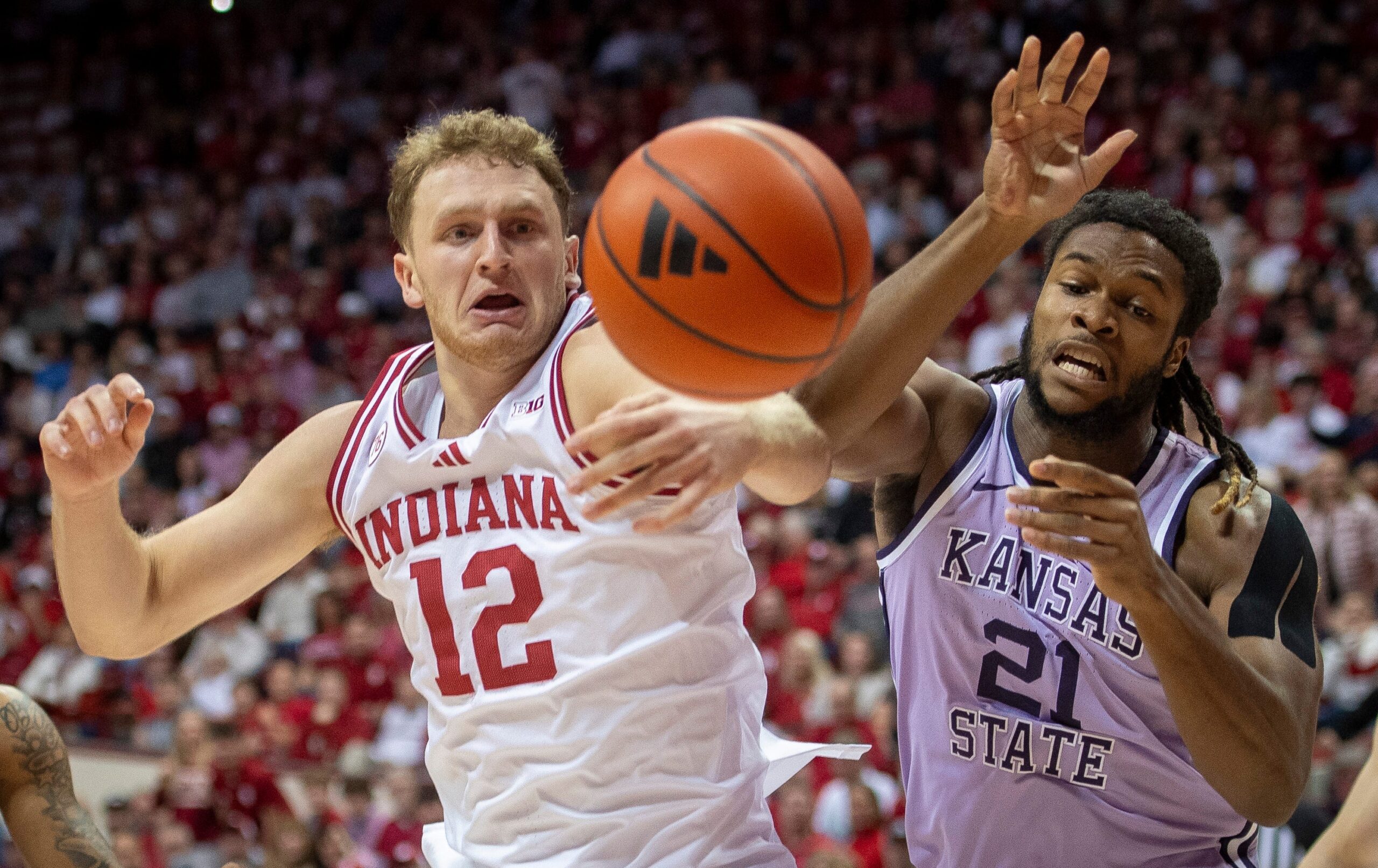 Indiana's Tucker DeVries (12) and Kansas State's Khamari McGriff (21) go for a rebound during the Indiana versus Kansas State men's basketball game at Simon Skjodt Assembly Hall on Tuesday, Nov. 25, 2025.