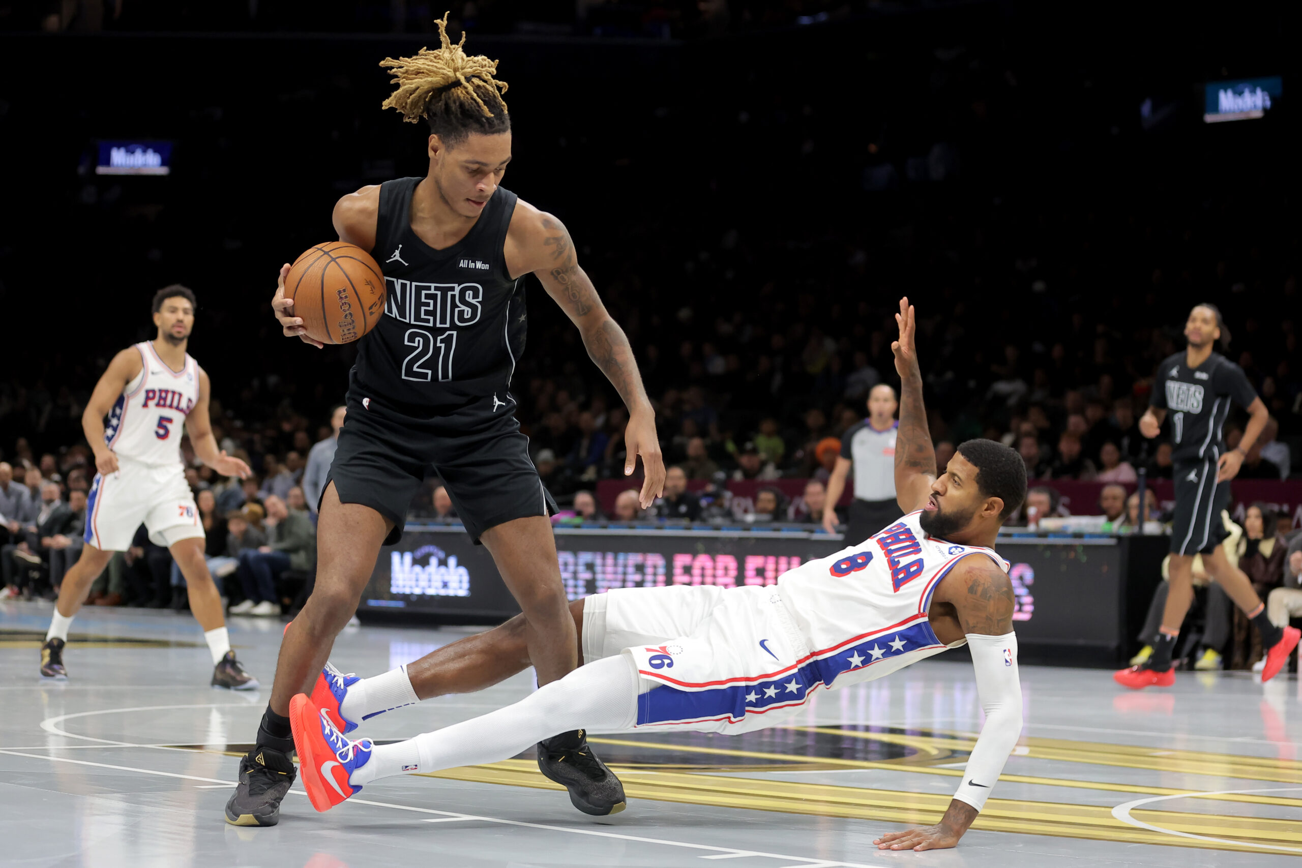 Nov 28, 2025; Brooklyn, New York, USA; Brooklyn Nets forward Noah Clowney (21) controls the ball against Philadelphia 76ers forward Paul George (8) during the third quarter at Barclays Center. Mandatory Credit: Brad Penner-Imagn Images