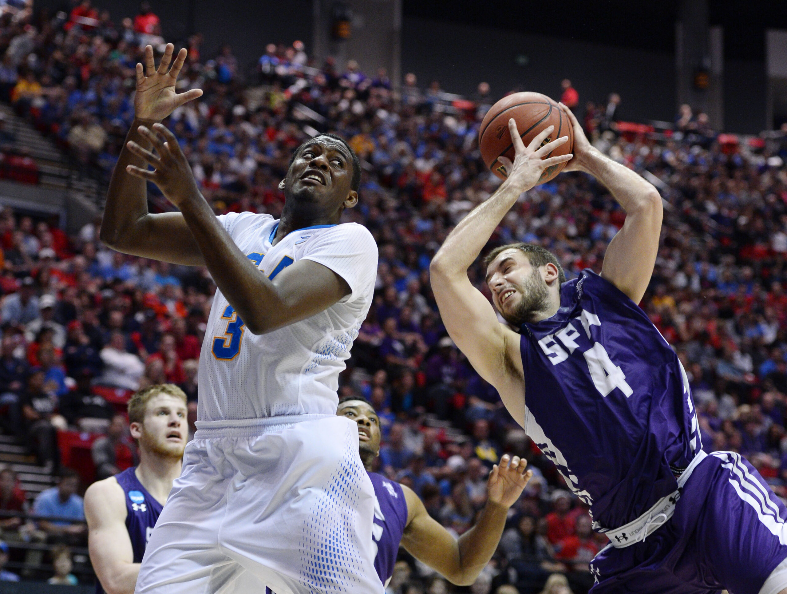 Mar 23, 2014; San Diego, CA, USA; UCLA Bruins guard Jordan Adams (3) battles for a rebound with Stephen F. Austin Lumberjacks forward Nikola Gajic (4) in the second half of a men's college basketball game during the third round of the 2014 NCAA Tournament at Viejas Arena. Mandatory Credit: Christopher Hanewinckel-Imagn Images