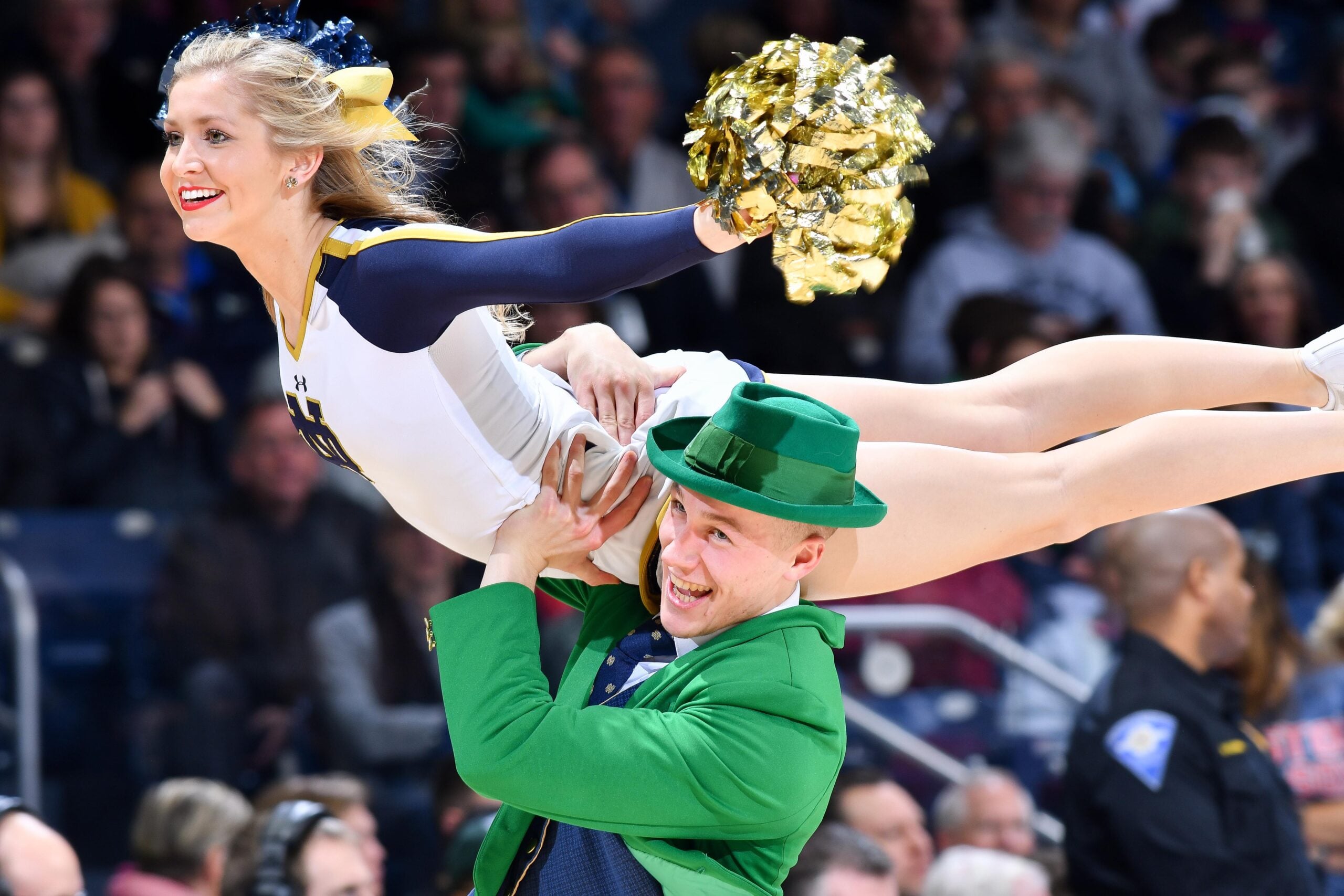 Jan 12, 2019; South Bend, IN, USA; The Notre Dame Leprechaun carries a cheerleader during a time out in the second half of the game between the Notre Dame Fighting Irish and the Boston College Eagles at the Purcell Pavilion. Mandatory Credit: Matt Cashore-Imagn Images