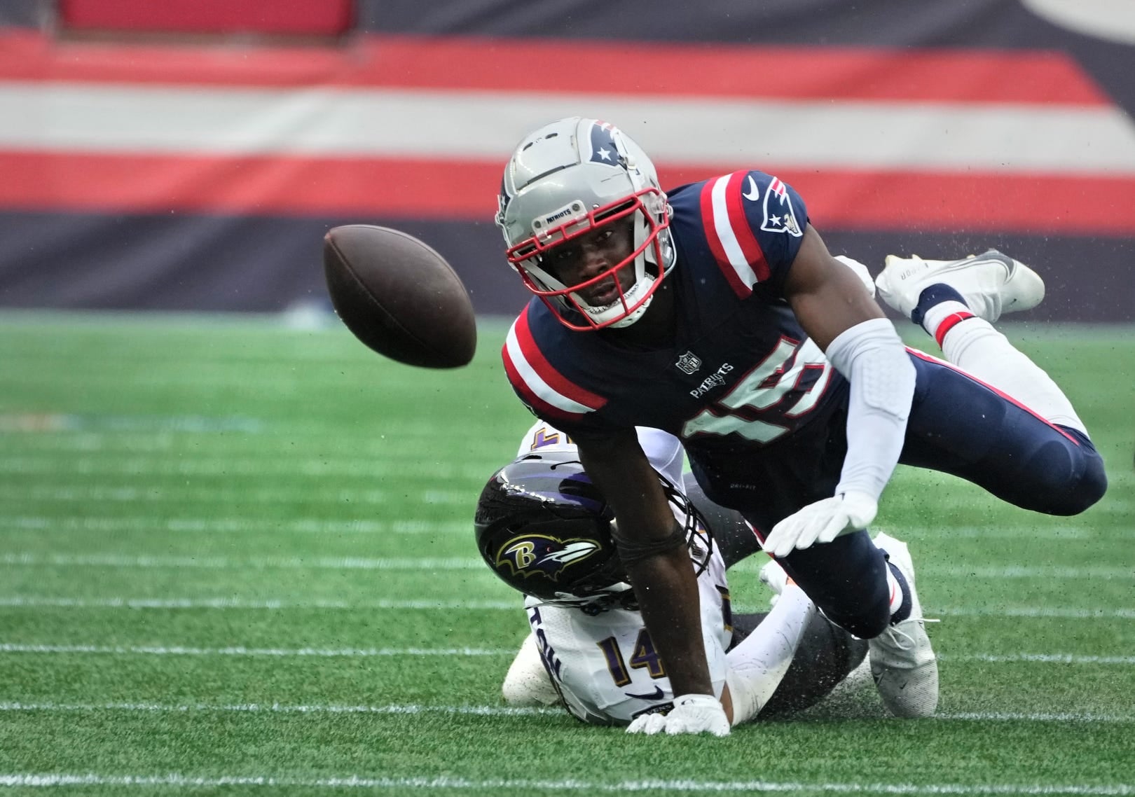 New England receiver Nelson Agholor , being brought down by Raven defender Kyle Hamilton, watches as his fumbled ball bounces away after a 28yard, 4th quarter run.   The ball was recovered by the Ravens and ended Patriots chances of a comeback win.   [The Providence Journal / Kris Craig]