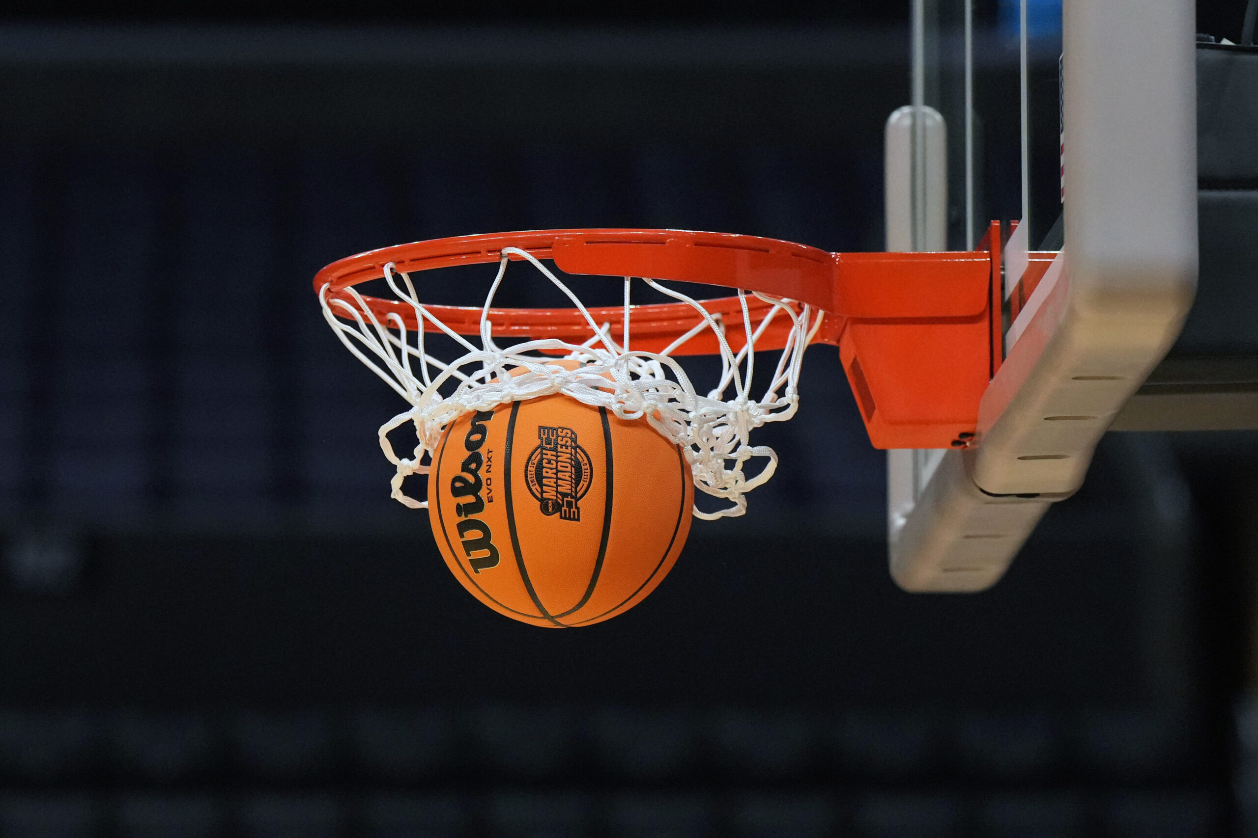 Mar 27, 2024; Los Angeles, CA, USA; A Wilson official Evo NXT game basketball with March Madness and Elite 8 and Sweet logo approaches the rim and net at Crypto.com Arena. Mandatory Credit: Kirby Lee-Imagn Images