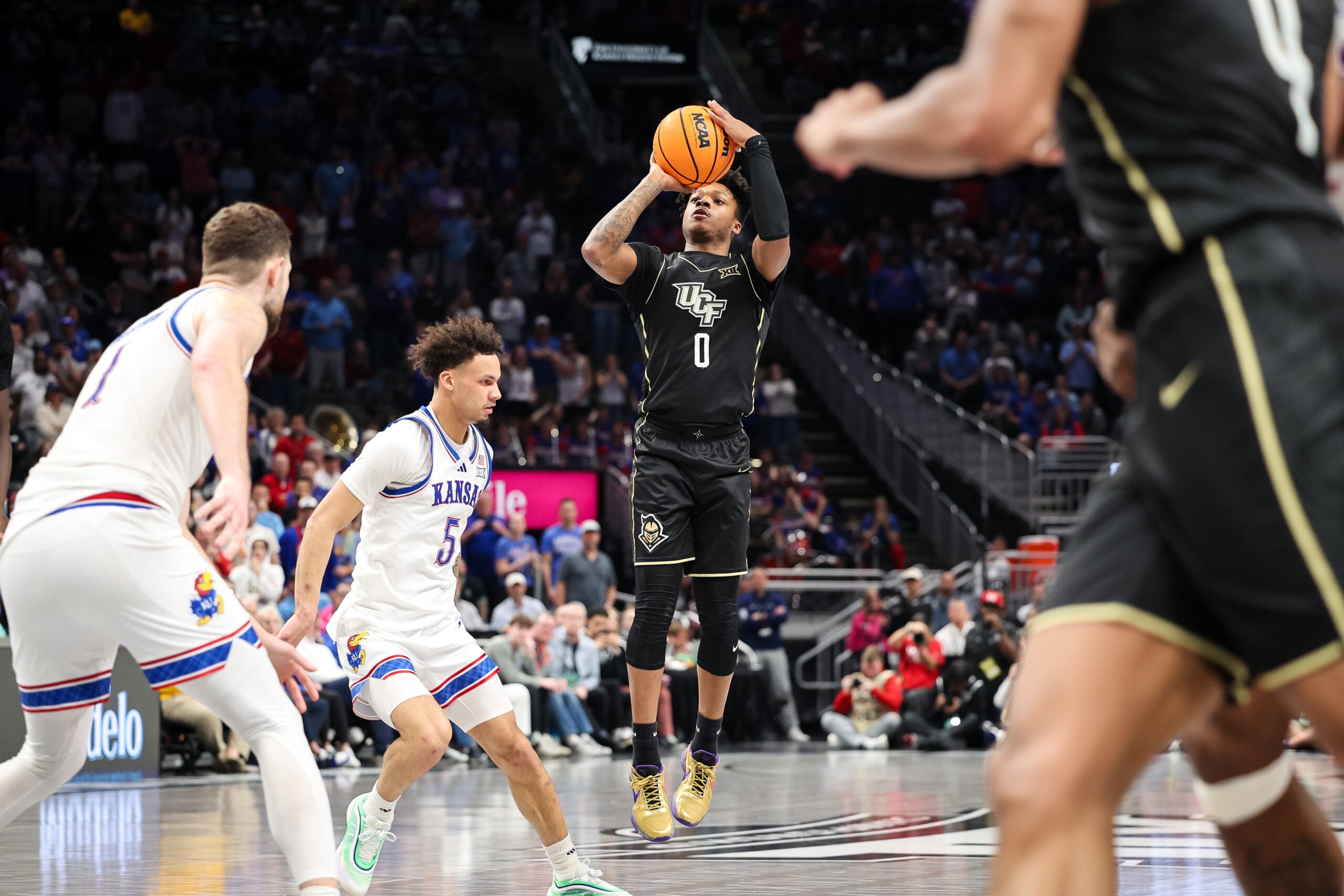 Mar 12, 2025; Kansas City, MO, USA; UCF Knights guard Jordan Ivy-Curry (0) shoots the ball during the second half against the Kansas Jayhawks at T-Mobile Center. Mandatory Credit: William Purnell-Imagn Images