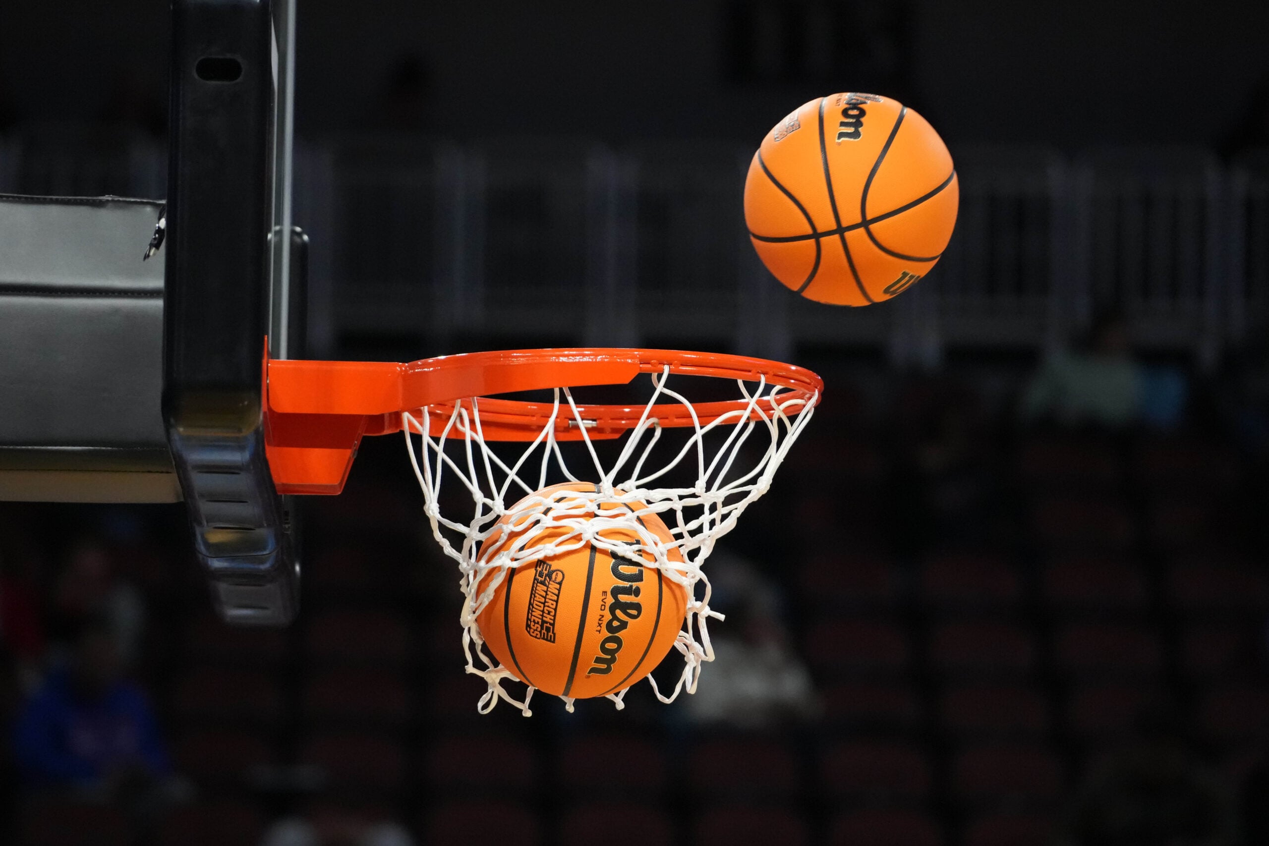 Mar 19, 2025; Wichita, KS, USA; Wilson Evo NXT official basketballs with March Madness logo approach the rim and the net at Intrust Bank Arena. Mandatory Credit: Kirby Lee-Imagn Images