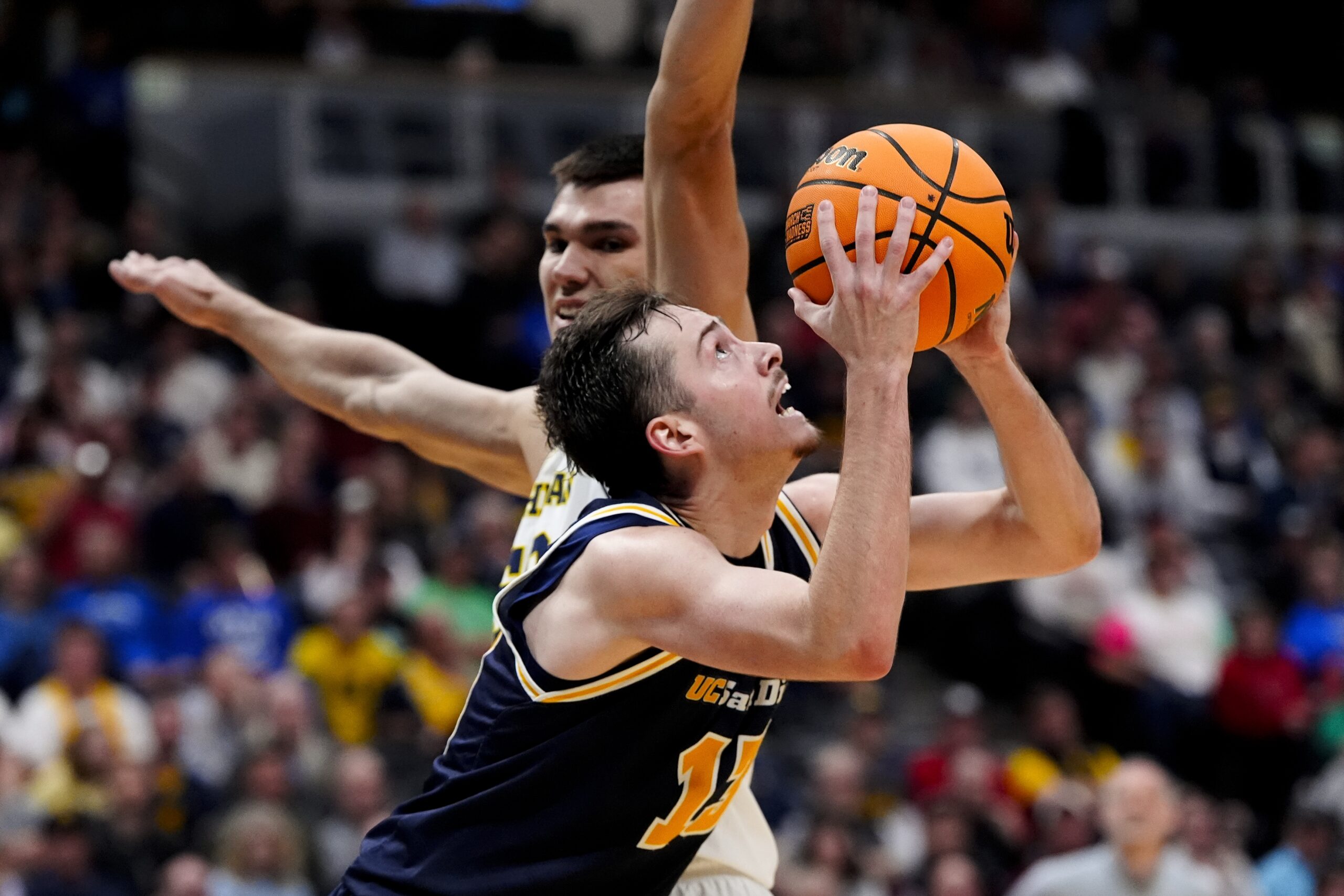 March 20, 2025; Denver, CO, USA; UC San Diego Tritons guard Tyler McGhie (13) attempts to shoot the ball as Michigan Wolverines center Vladislav Goldin (50) defends during the second half at Ball Arena. Mandatory Credit: Ron Chenoy-Imagn Images