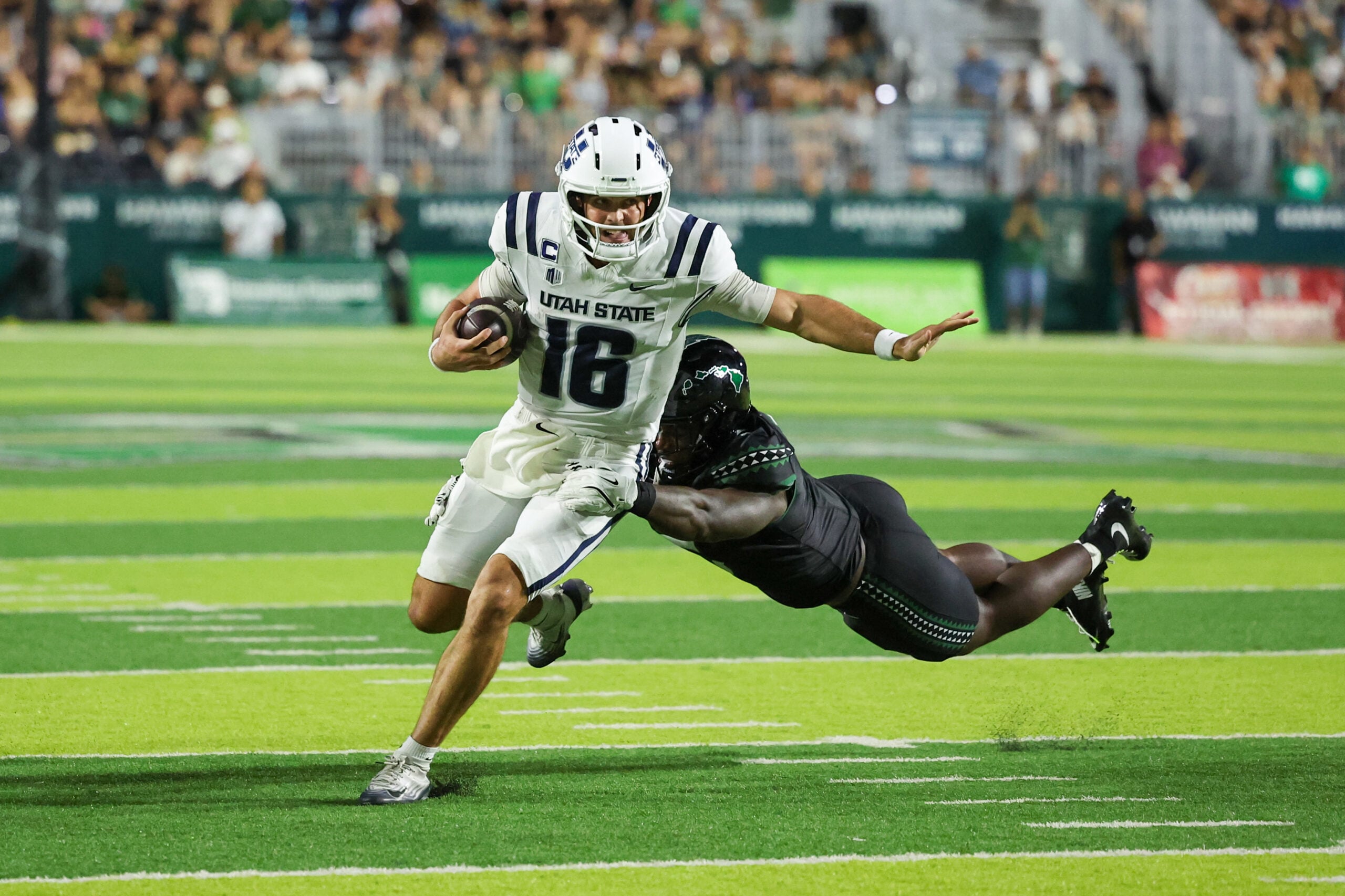 Oct 11, 2025; Honolulu, Hawaii, USA; Hawaii Rainbow Warriors defensive lineman Tariq Jones (5) dives at Utah State Aggies quarterback Bryson Barnes (16) during the first half at Clarence T.C. Ching Athletics Complex. Mandatory Credit: Marco Garcia-Imagn Images