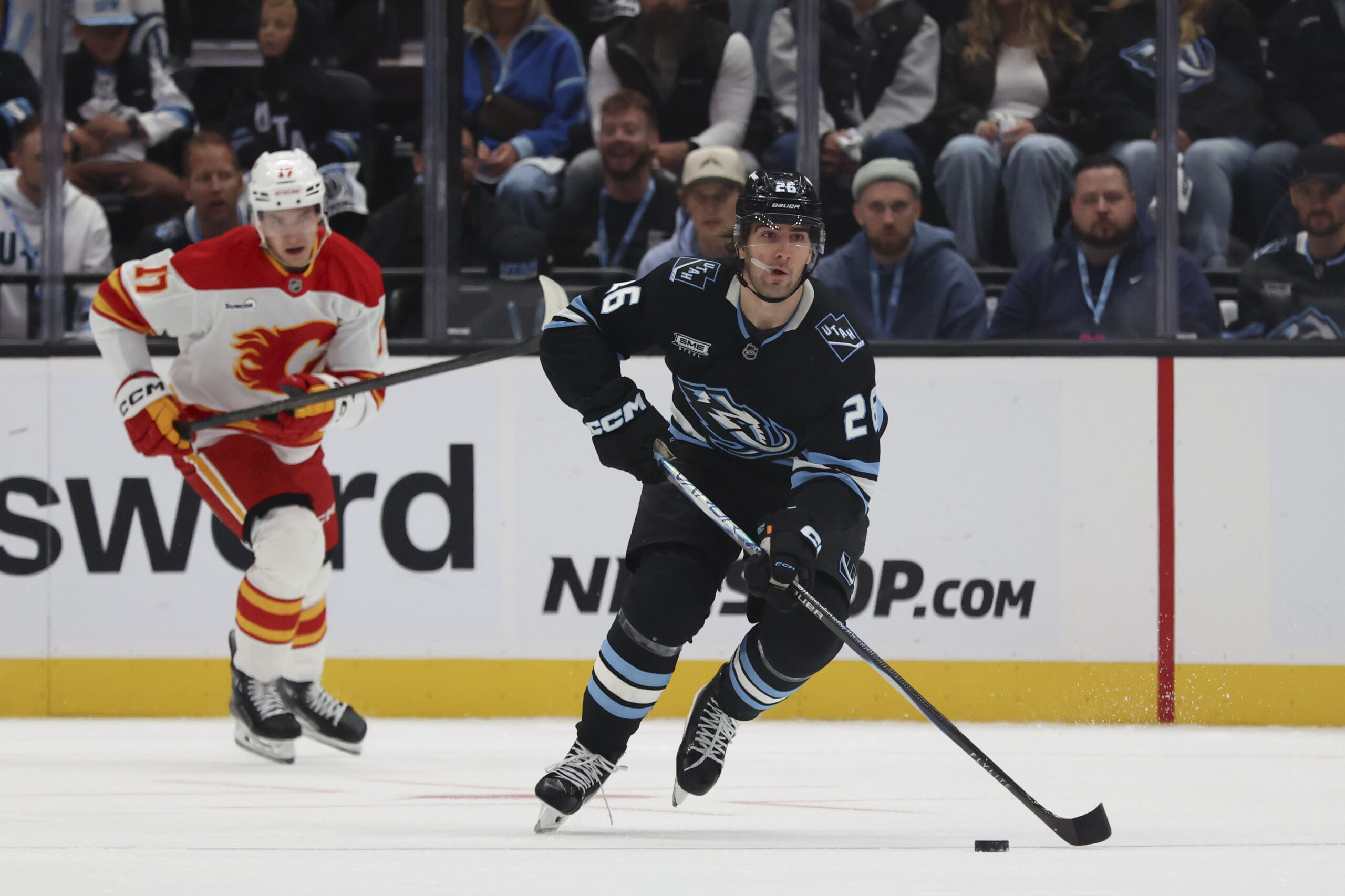 Oct 15, 2025; Salt Lake City, Utah, USA; Utah Mammoth defenseman Dmitri Simashev (26) skates with the puck against the Calgary Flames during the first period at Delta Center. Mandatory Credit: Rob Gray-Imagn Images