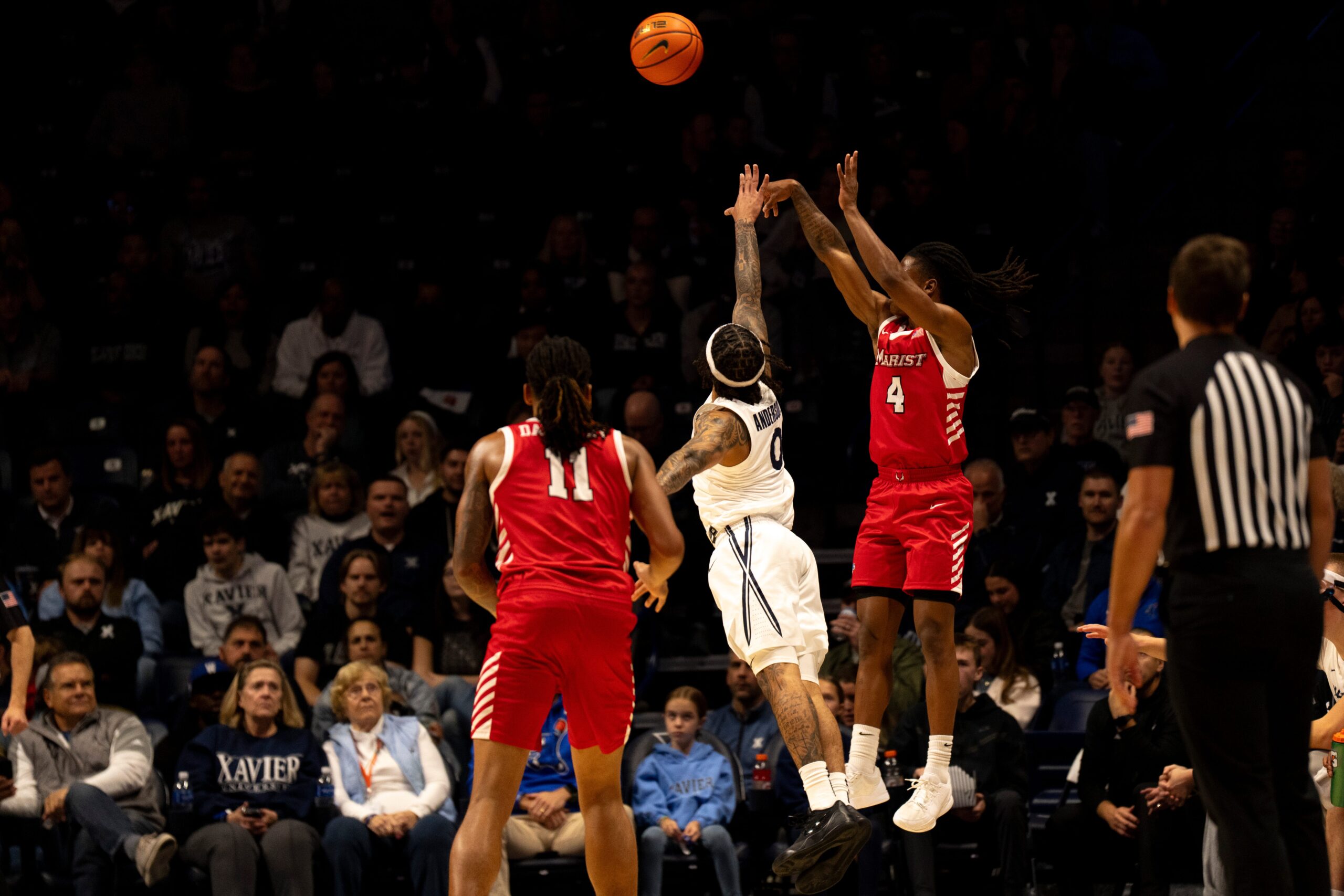Marist Red Foxes guard Rhyjon Blackwell (4) hits a 3-point shot over Xavier Musketeers guard Roddie Anderson III (0) in the first half of the basketball game at the Cintas Center on Nov. 3, 2025.
