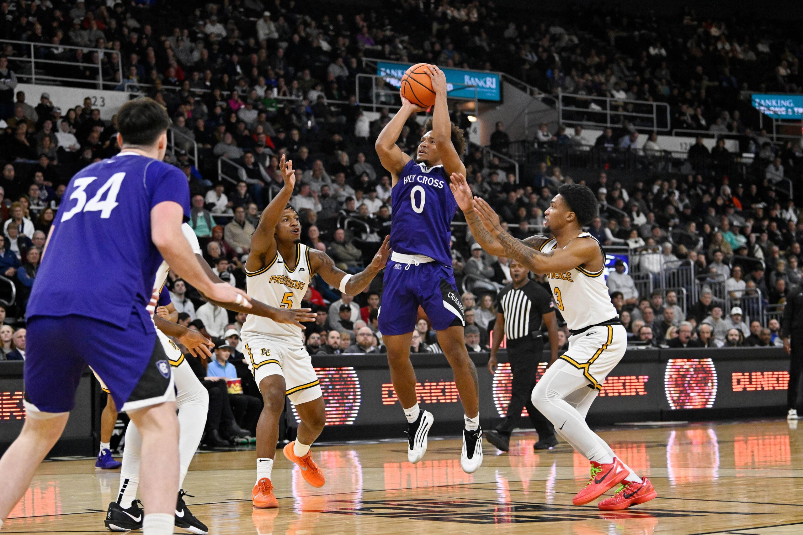 Nov 3, 2025; Providence, Rhode Island, USA; Holy Cross Crusaders guard Tyler Boston (0) shoots over the defense of Providence Friars forward Jamier Jones (5) and guard Daquan Davis (3) during the second half at Amica Mutual Pavilion. Mandatory Credit: Eric Canha-Imagn Images