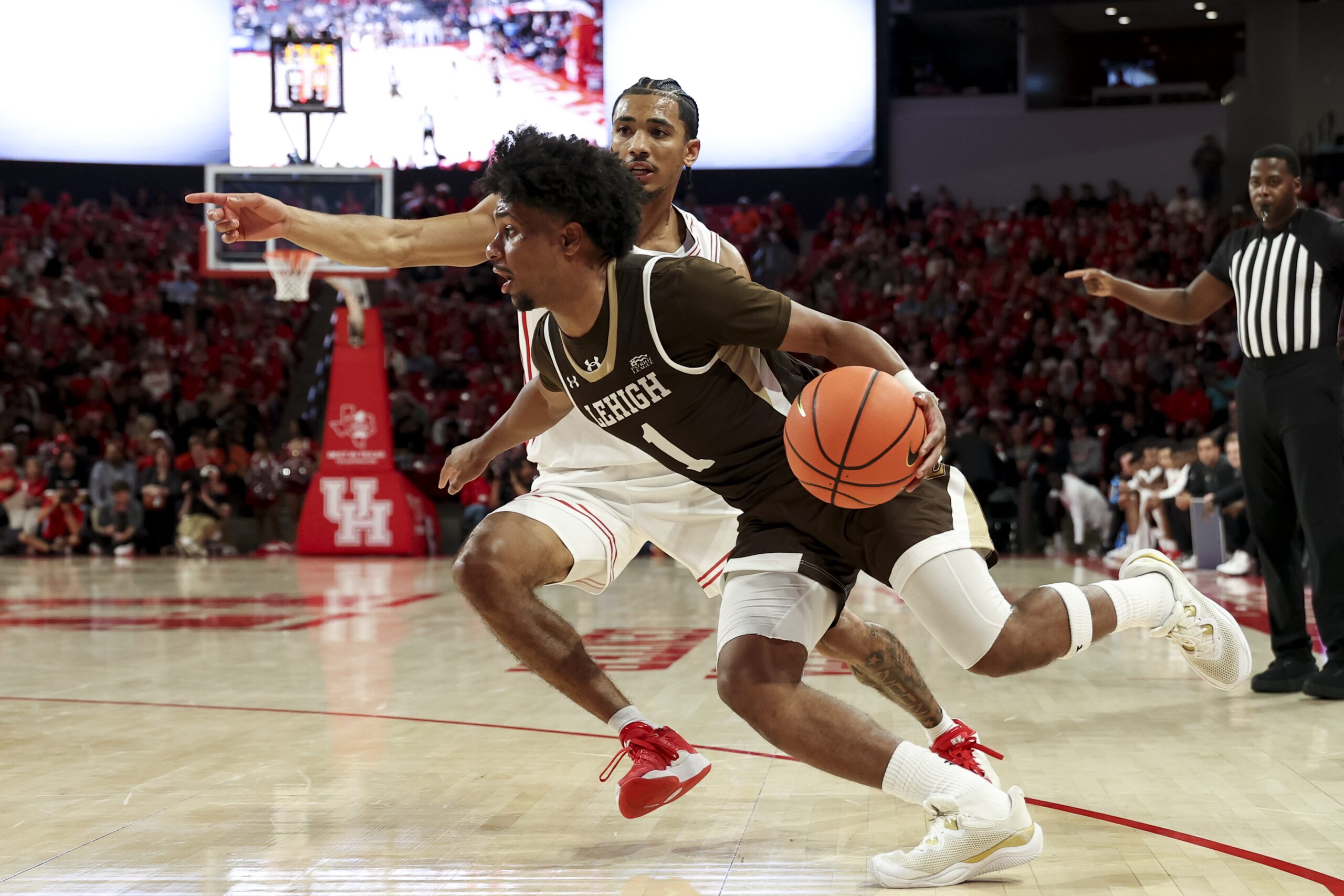 Nov 3, 2025; Houston, Texas, USA; Lehigh Mountain Hawks guard Nasir Whitlock (1) drives as Houston Cougars guard Milos Uzan (7) defends during the second half at Fertitta Center. Mandatory Credit: Maria Lysaker-Imagn Images