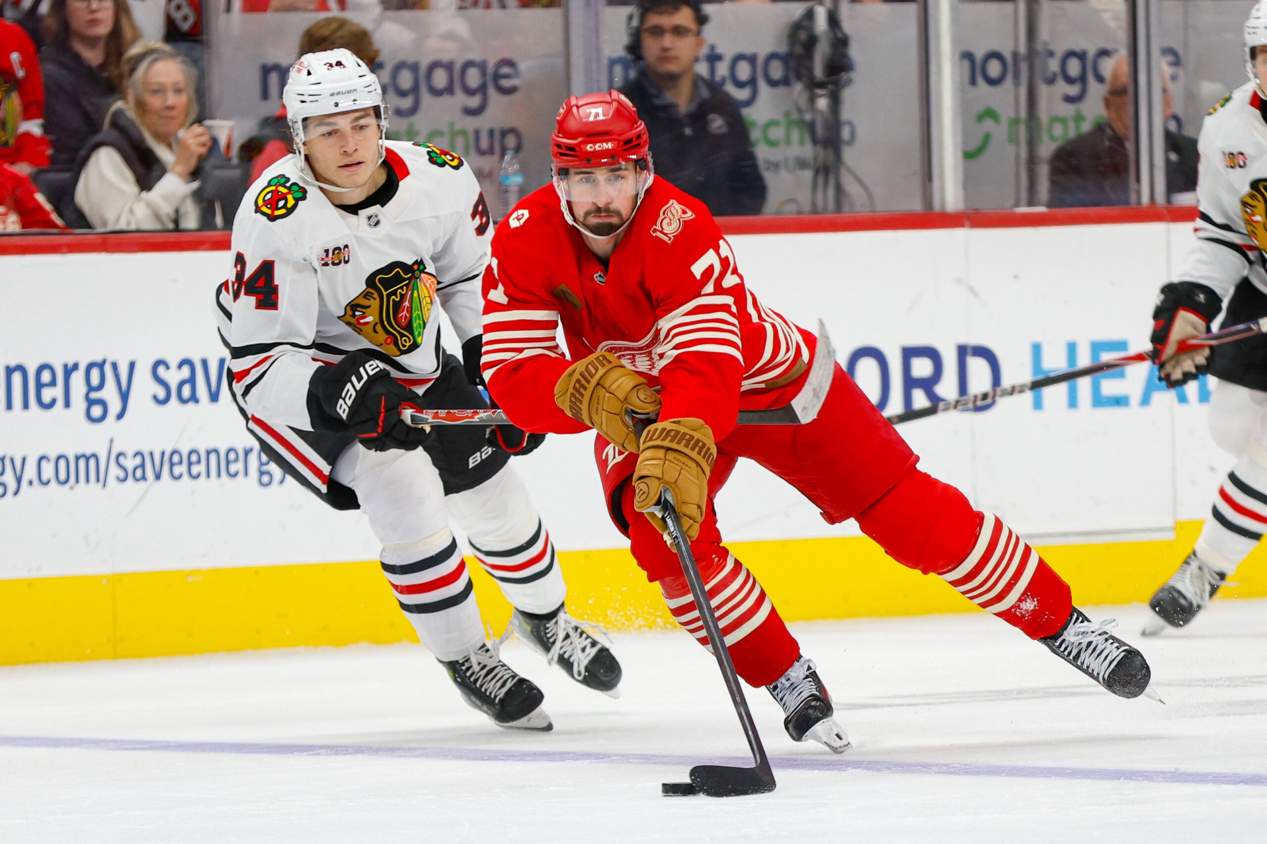 Nov 9, 2025; Detroit, Michigan, USA; Detroit Red Wings center Dylan Larkin (71) handles the puck against Chicago Blackhawks center Colton Dach (34) during the second period at Little Caesars Arena. Mandatory Credit: Brian Bradshaw Sevald-Imagn Images