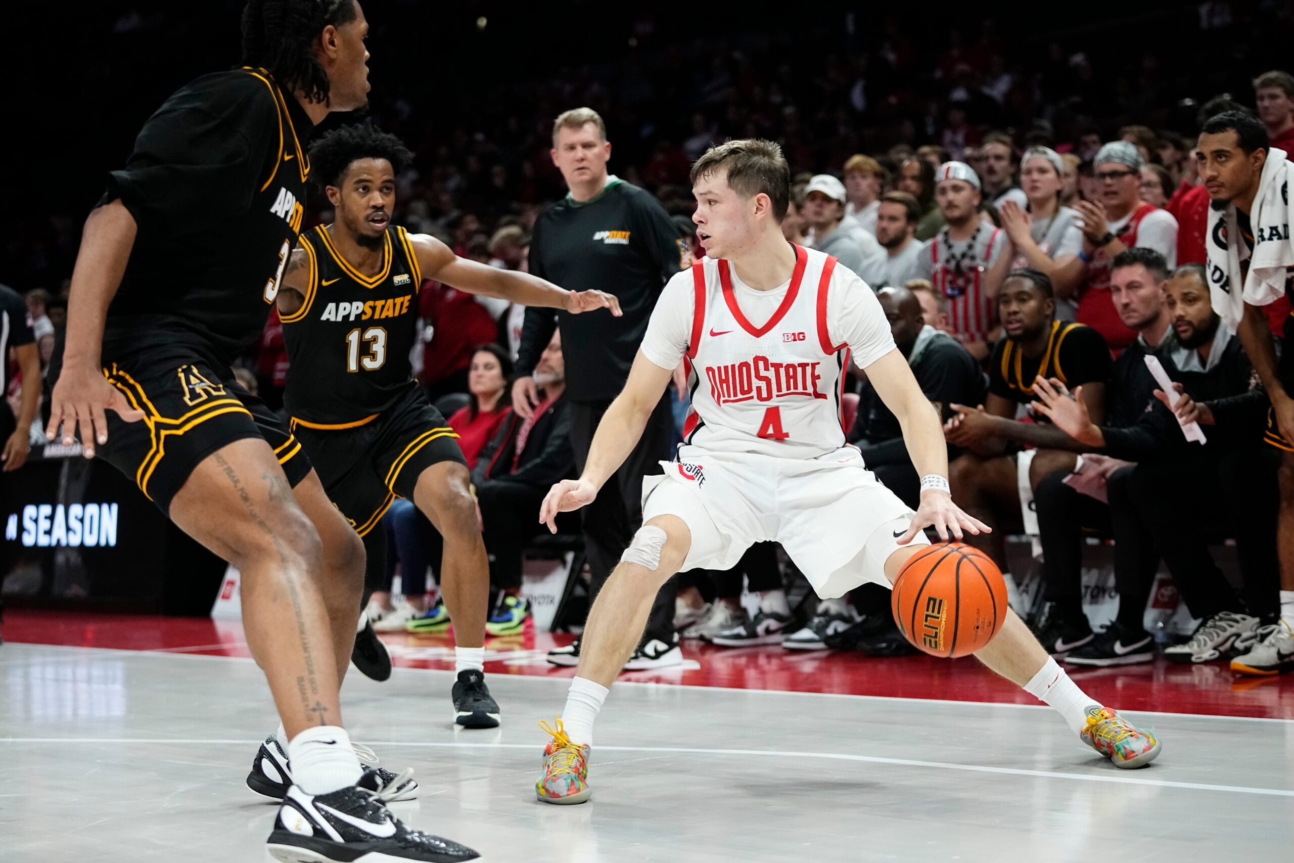 Ohio State Buckeyes guard Gabe Cupps (4) dribbles between Appalachian State Mountaineers center Luke Wilson (3) and guard Kasen Jennings (13) during the NCAA men's basketball game at Value City Arena in Columbus on Nov. 11, 2025.