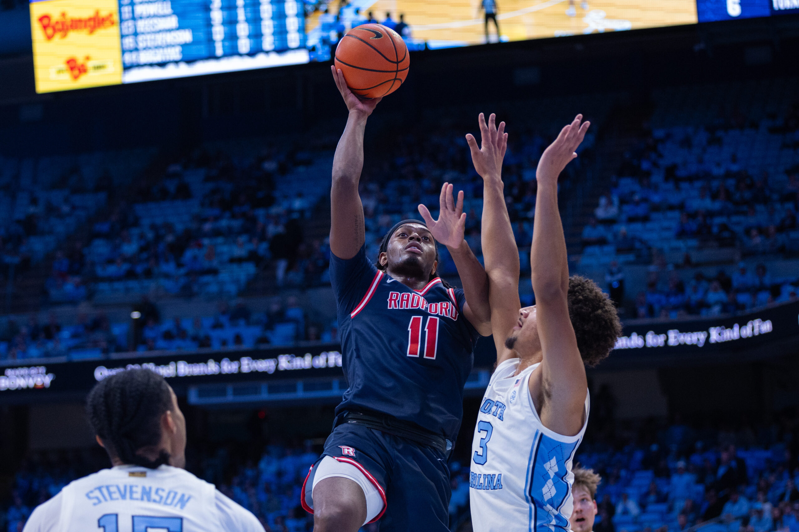 Nov 11, 2025; Chapel Hill, North Carolina, USA; Radford Highlanders guard Jr. Dennis Parker (11) shoots on North Carolina Tar Heels guard Derek Dixon (3) during the first half at Dean E. Smith Center. Mandatory Credit: Scott Kinser-Imagn Images