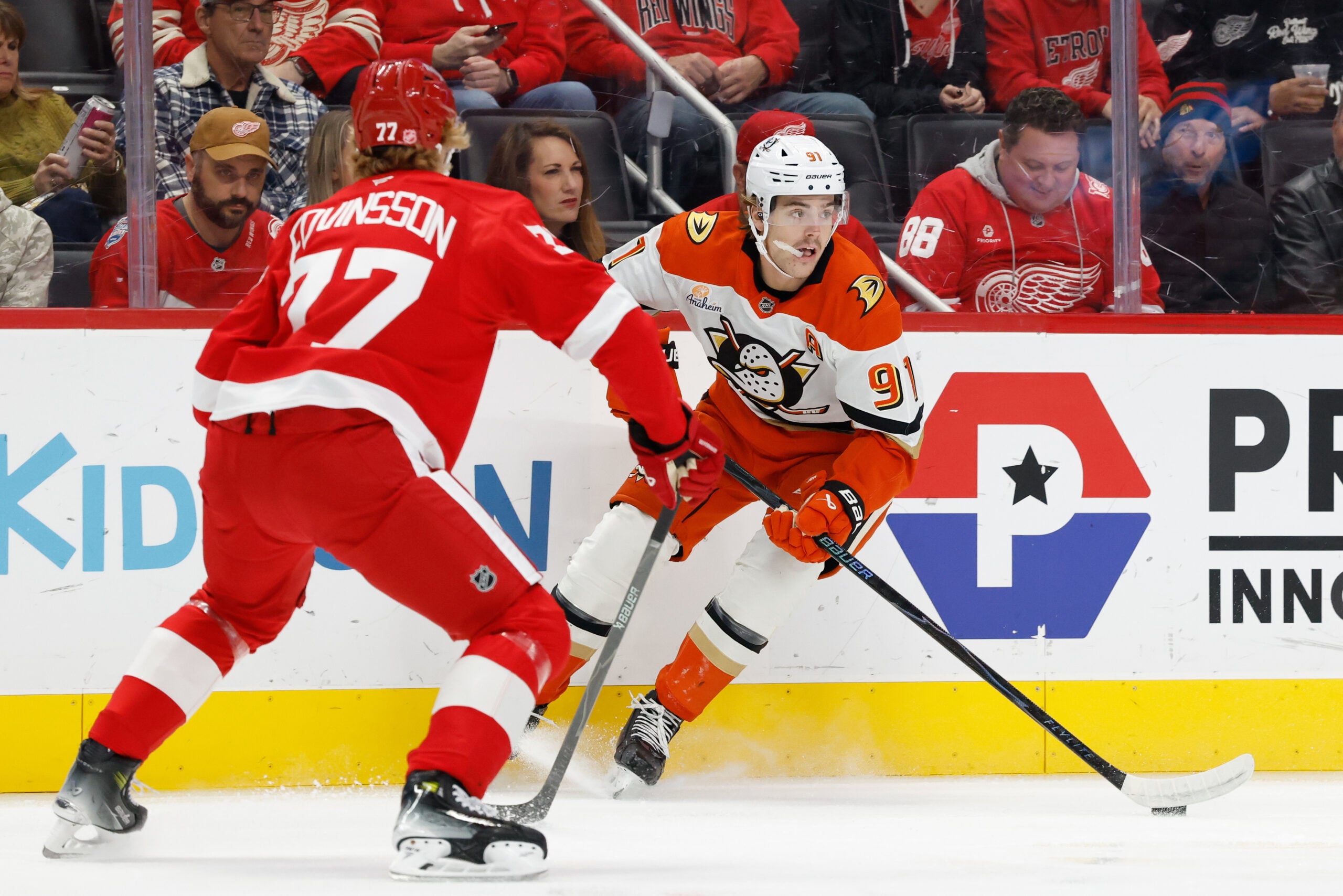 Nov 13, 2025; Detroit, Michigan, USA; Anaheim Ducks center Leo Carlsson (91) skates with the puck defended by Detroit Red Wings defenseman Simon Edvinsson (77) in the first period at Little Caesars Arena. Mandatory Credit: Rick Osentoski-Imagn Images
