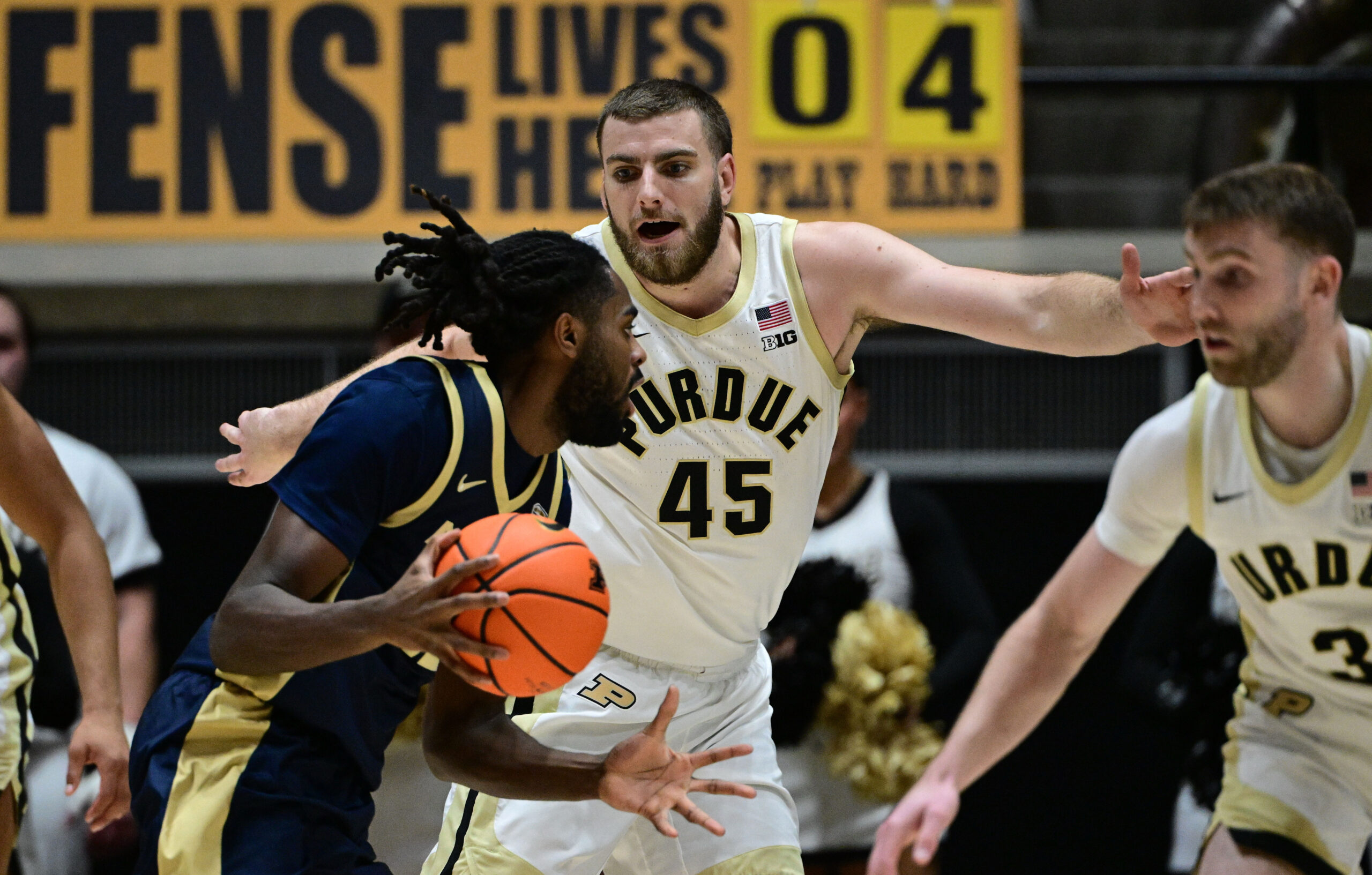 Nov 16, 2025; West Lafayette, Indiana, USA; Akron Zips guard Evan Mahaffey (12) looks to get past Purdue Boilermakers center Oscar Cluff (45) during the second half at Mackey Arena. Mandatory Credit: Marc Lebryk-Imagn Images
