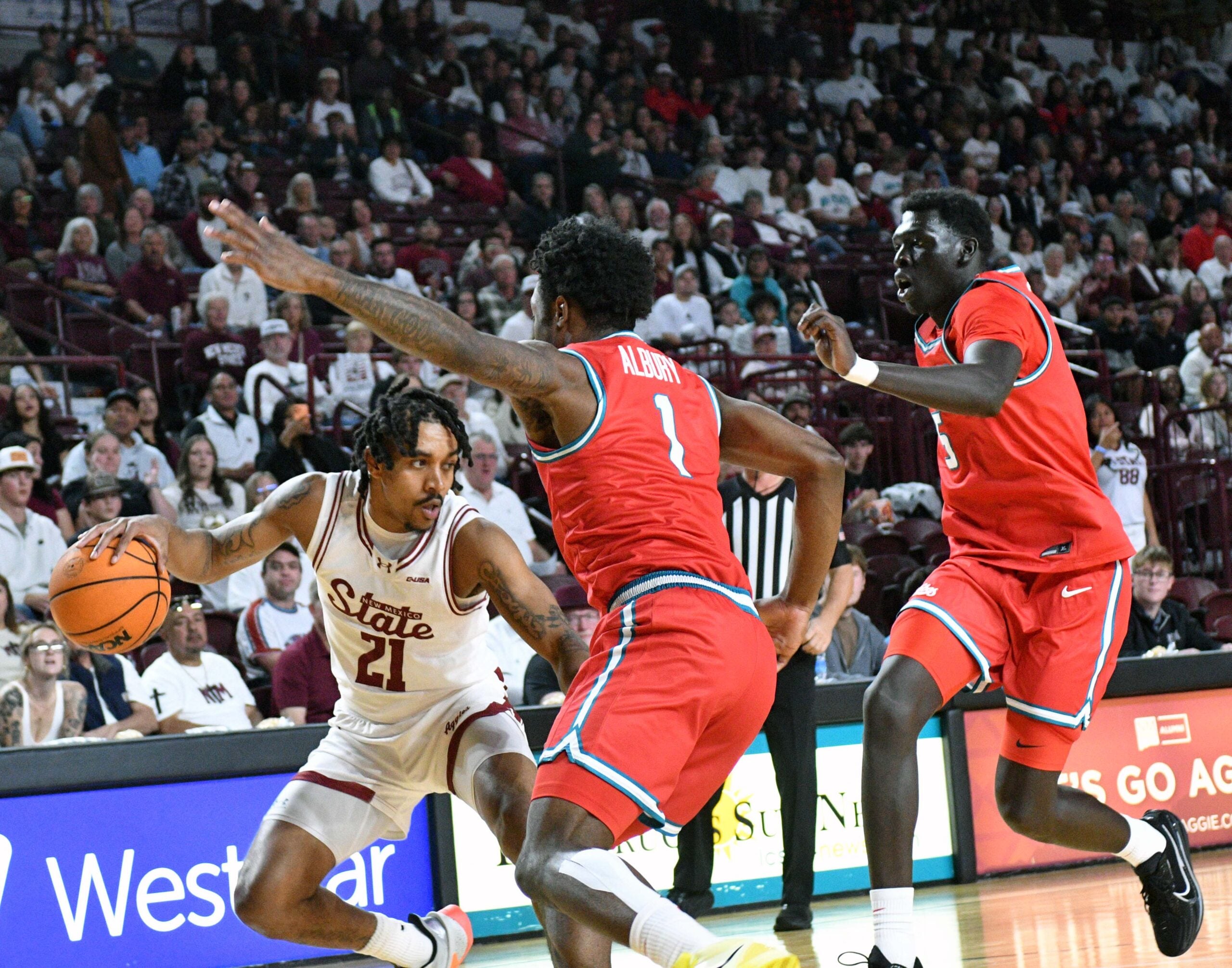 NMSU's Jemel Jones looks to make a pass to a teammate along the baseline as the Aggies took on the Lobos on Saturday night in Las Cruces.