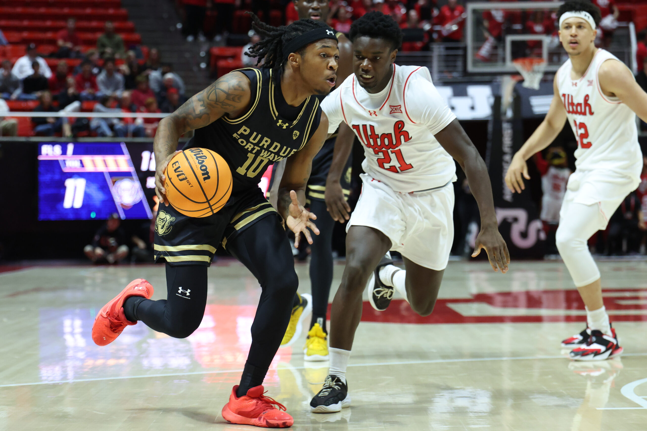 Nov 18, 2025; Salt Lake City, Utah, USA; Purdue Fort Wayne Mastodons guard Corey Hadnot II (10) drives against Utah Utes guard Obomate Abbey (21) during the first half at Jon M. Huntsman Center. Mandatory Credit: Rob Gray-Imagn Images