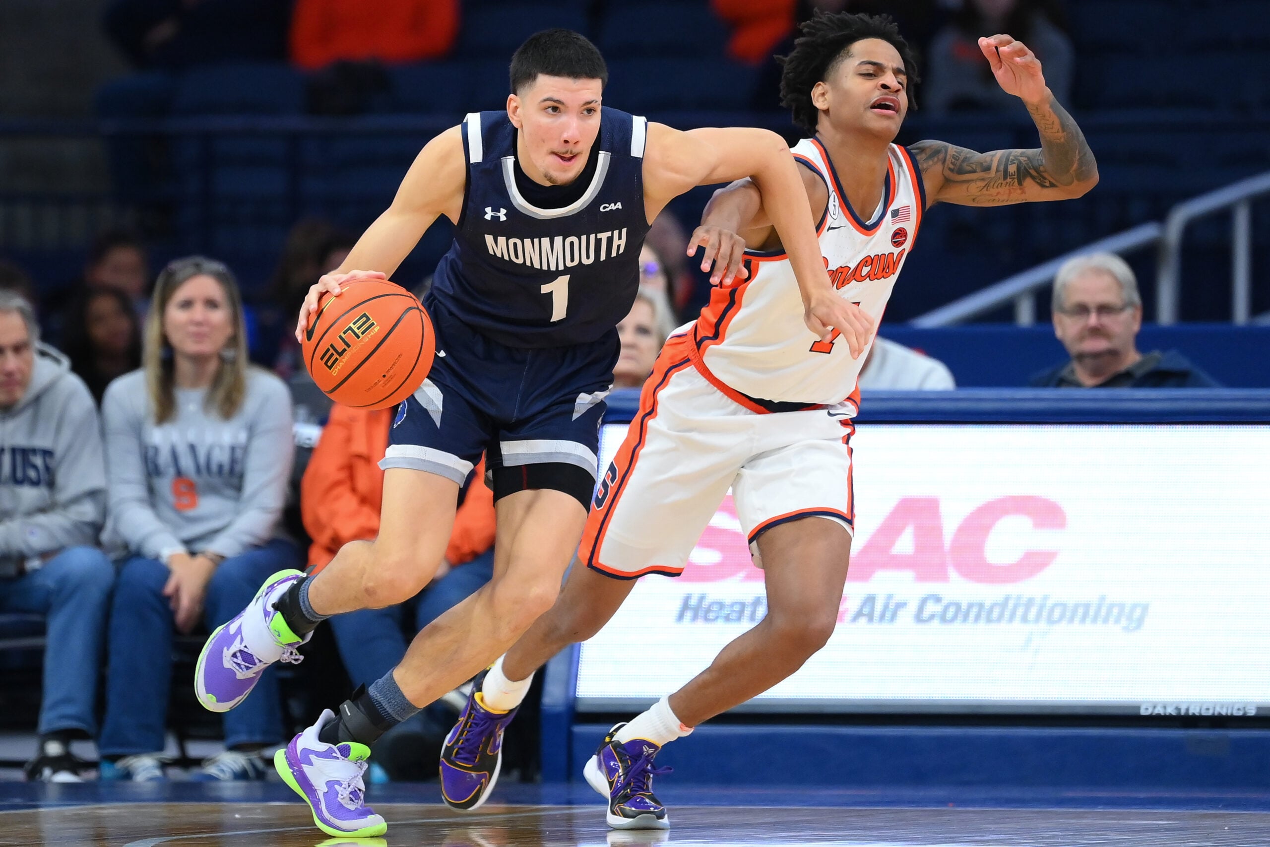 Nov 18, 2025; Syracuse, New York, USA; Monmouth Hawks forward Jason Rivera-Torres (1) drives against Syracuse Orange guard Kiyan Anthony (7) during the second half at the JMA Wireless Dome. Mandatory Credit: Rich Barnes-Imagn Images