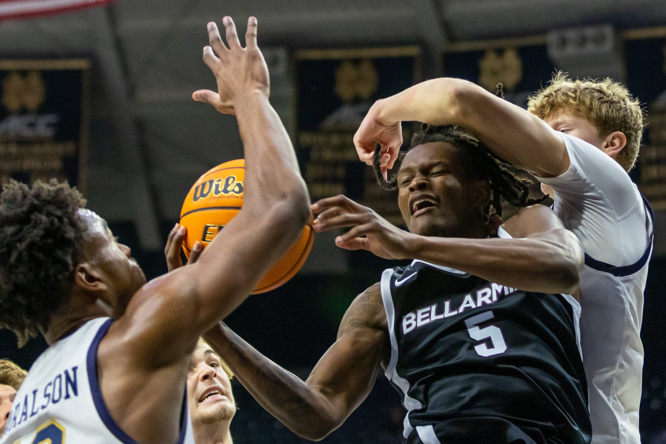 Nov 19, 2025; South Bend, Indiana, USA; Bellarmine Knights guard Myles Watkins (5) fights for a rebound against Notre Dame Fighting Irish guard Jalen Haralson, left, and forward Brady Koehler, right, during the second half at Purcell Pavilion at the Joyce Center. Mandatory Credit: Michael Caterina-Imagn Images