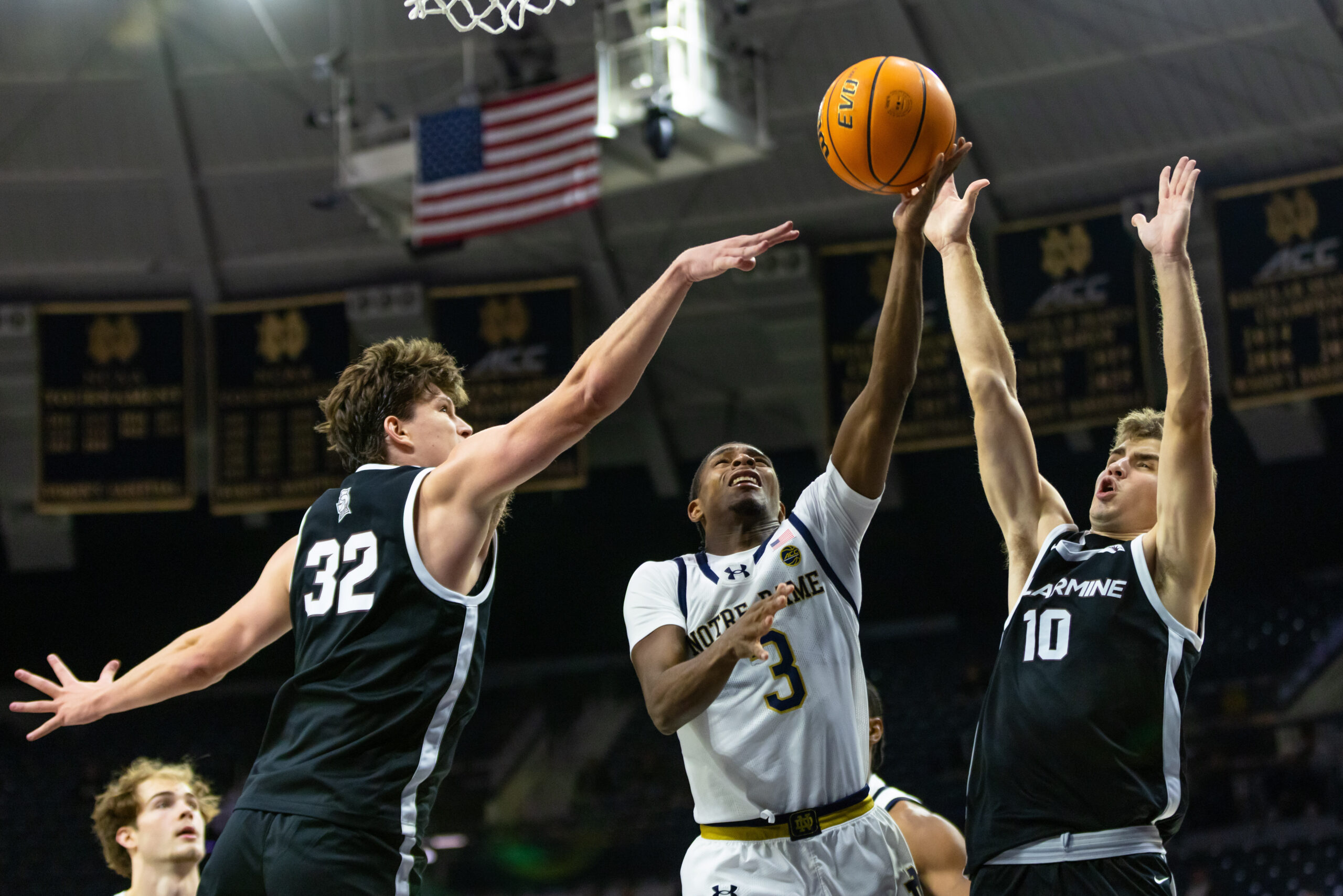 Nov 19, 2025; South Bend, Indiana, USA; Notre Dame Fighting Irish guard Markus Burton (3) puts up a shot as Bellarmine Knights forward Jack Karasinski (32) and guard Grant Whitaker (10) defend during the second half at Purcell Pavilion at the Joyce Center. Mandatory Credit: Michael Caterina-Imagn Images