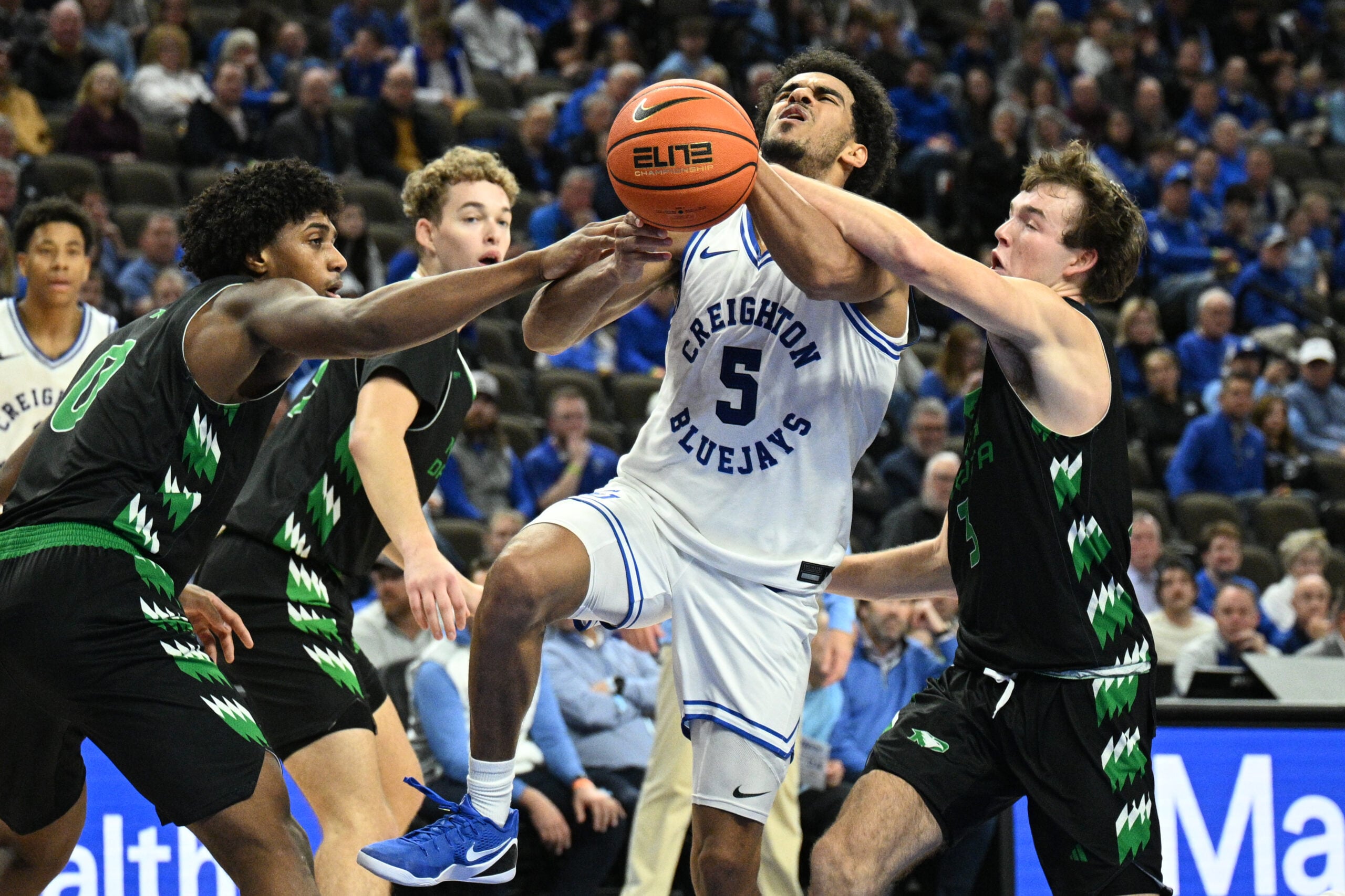 Nov 19, 2025; Omaha, Nebraska, USA; North Dakota Fighting Hawks guard Greyson Uelmen (3) fouls Creighton Bluejays guard Nik Graves (5) on a shot attempt during the second half at CHI Health Center Omaha. Mandatory Credit: Steven Branscombe-Imagn Images