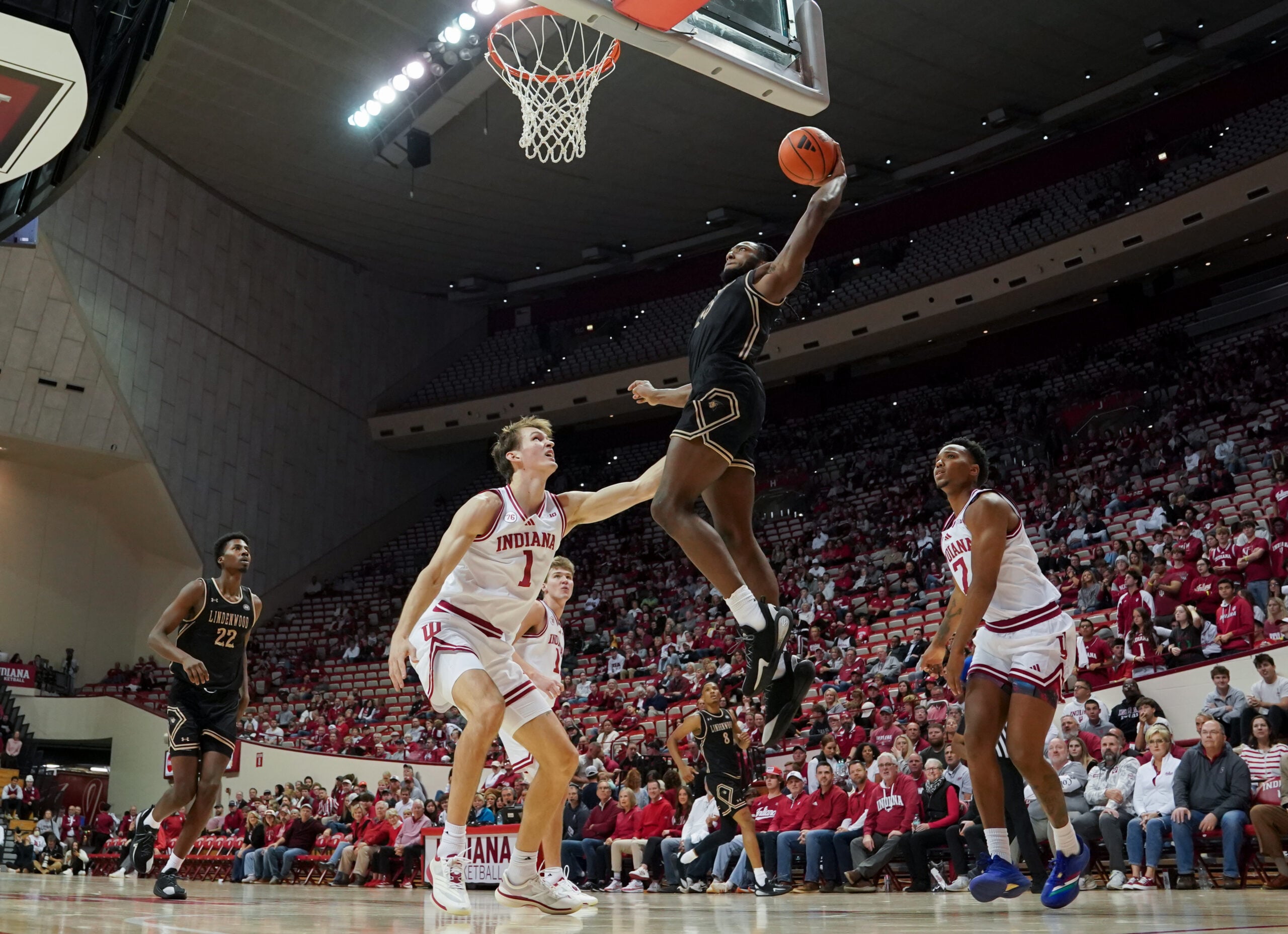 Nov 20, 2025; Bloomington, Indiana, USA; Lindenwood Lions guard Jadis Jones (10) dunks the ball past Indiana Hoosiers forward Reed Bailey (1) during the second half at Simon Skjodt Assembly Hall. Mandatory Credit: Robert Goddin-Imagn Images