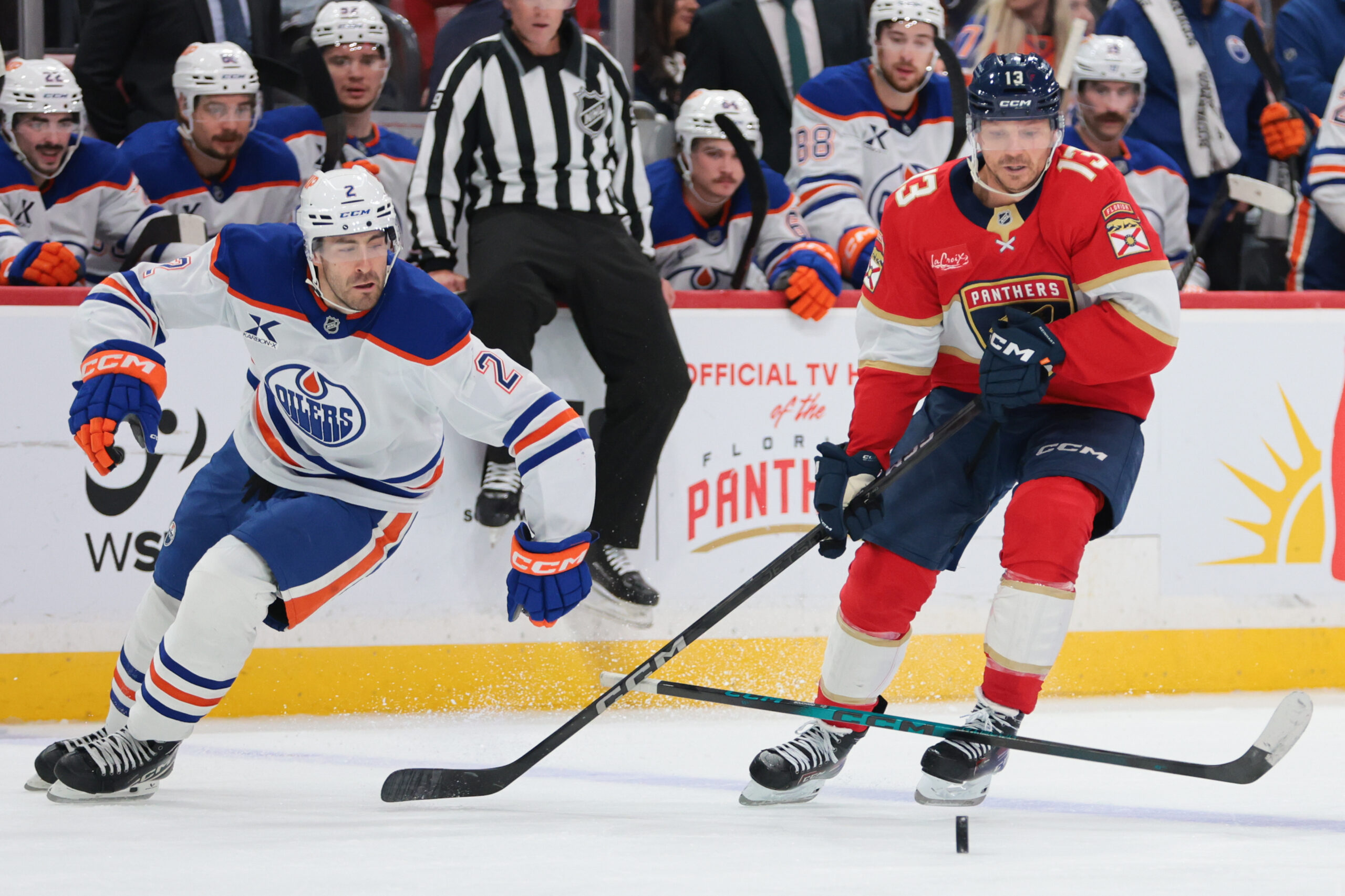 Nov 22, 2025; Sunrise, Florida, USA; Florida Panthers center Sam Reinhart (13) moves the puck against Edmonton Oilers defenseman Evan Bouchard (2) during the third period at Amerant Bank Arena. Mandatory Credit: Sam Navarro-Imagn Images
