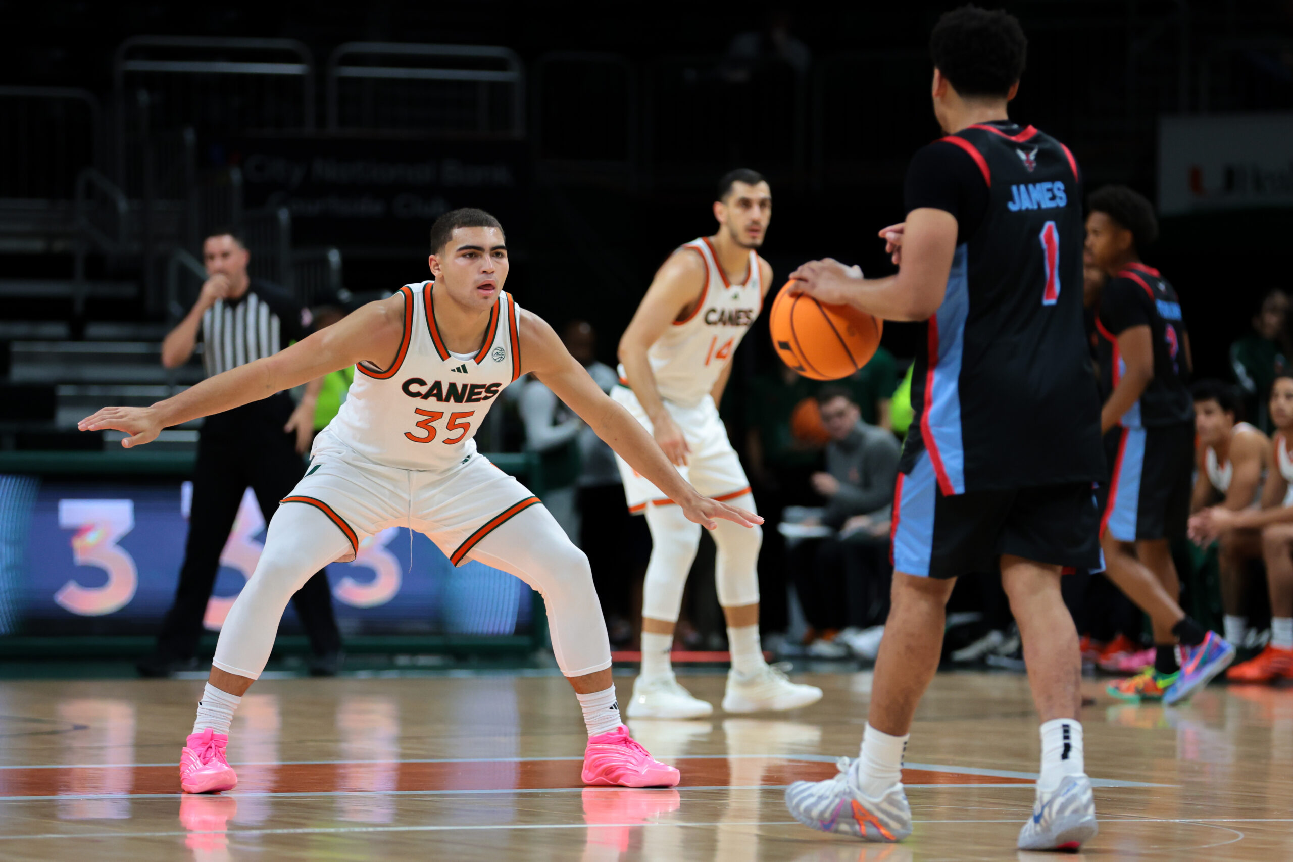 Nov 23, 2025; Coral Gables, Florida, USA; Miami Hurricanes guard Dante Allen (35) defends against Delaware State Hornets guard Ponce James (1) during the first half at Watsco Center. Mandatory Credit: Sam Navarro-Imagn Images