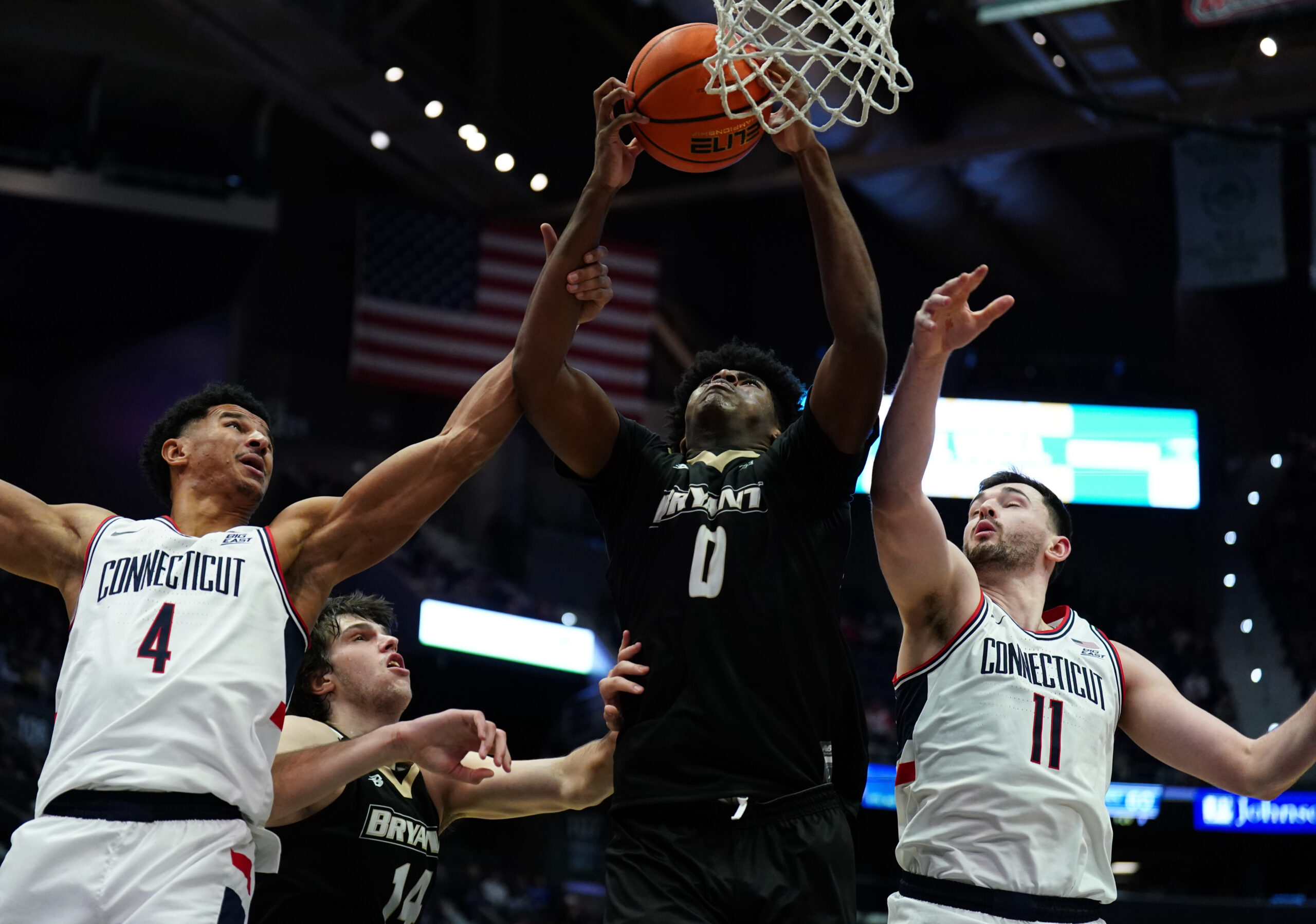Nov 23, 2025; Hartford, Connecticut, USA; Bryant Bulldogs forward Ii Ashley Sims (0) works for the ball against UConn Huskies forward Dwayne Koroma (4) and forward Alex Karaban (11) in the second half at Peoples Bank Arena. Mandatory Credit: David Butler II-Imagn Images