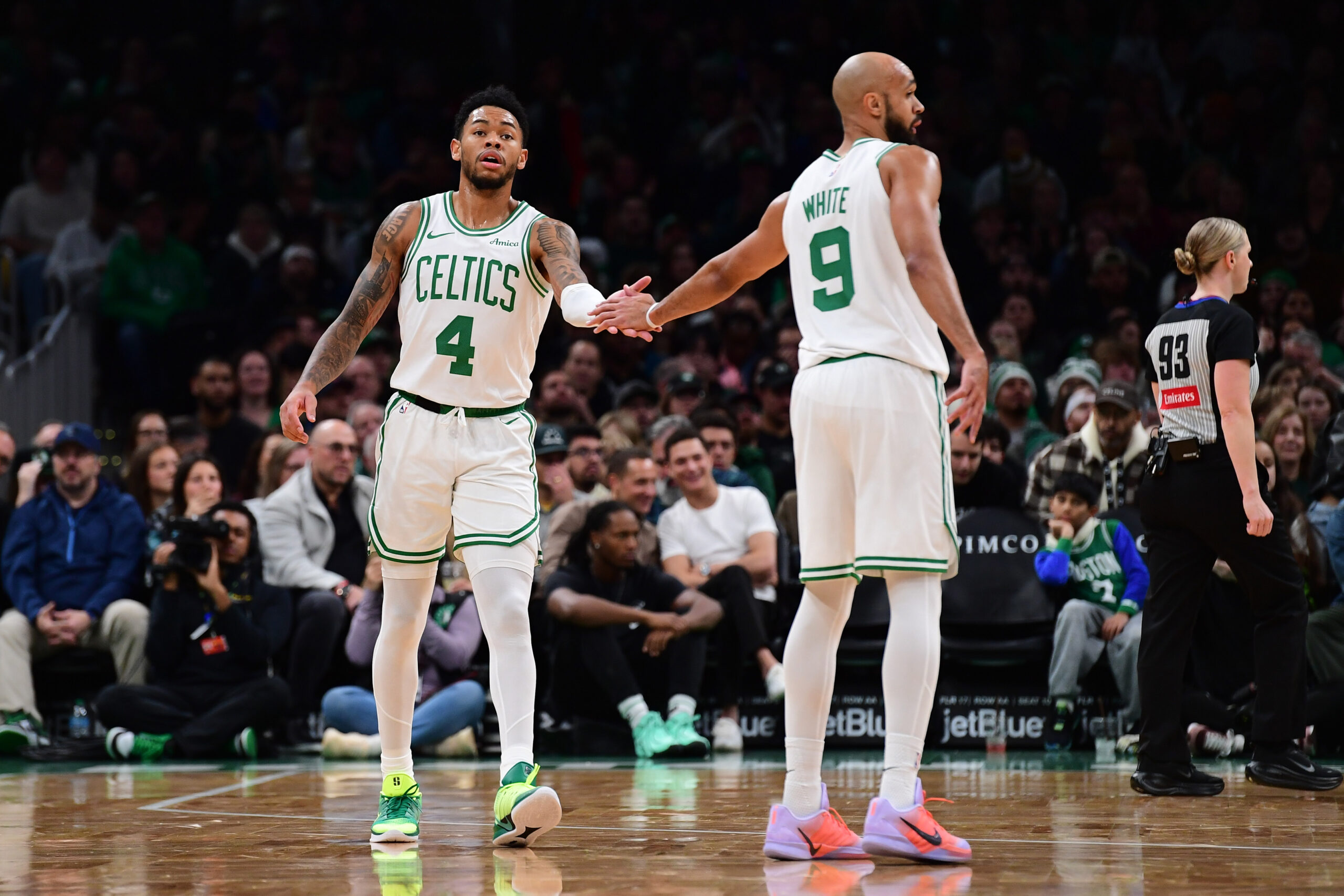 Nov 23, 2025; Boston, Massachusetts, USA; Boston Celtics guard Anfernee Simons (4) is congratulated by guard Derrick White (9) after a basket during the first half at TD Garden. Mandatory Credit: Bob DeChiara-Imagn Images