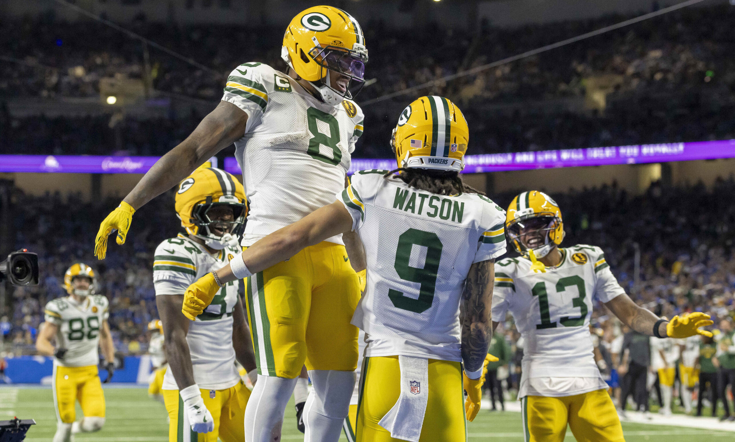 Nov 27, 2025; Detroit, Michigan, USA; Green Bay Packers running back Josh Jacobs (8) and Green Bay Packers wide receiver Christian Watson (9) celebrate after a touchdown against the Detroit Lions during the third quarter at Ford Field. Mandatory Credit: David Reginek-Imagn Images