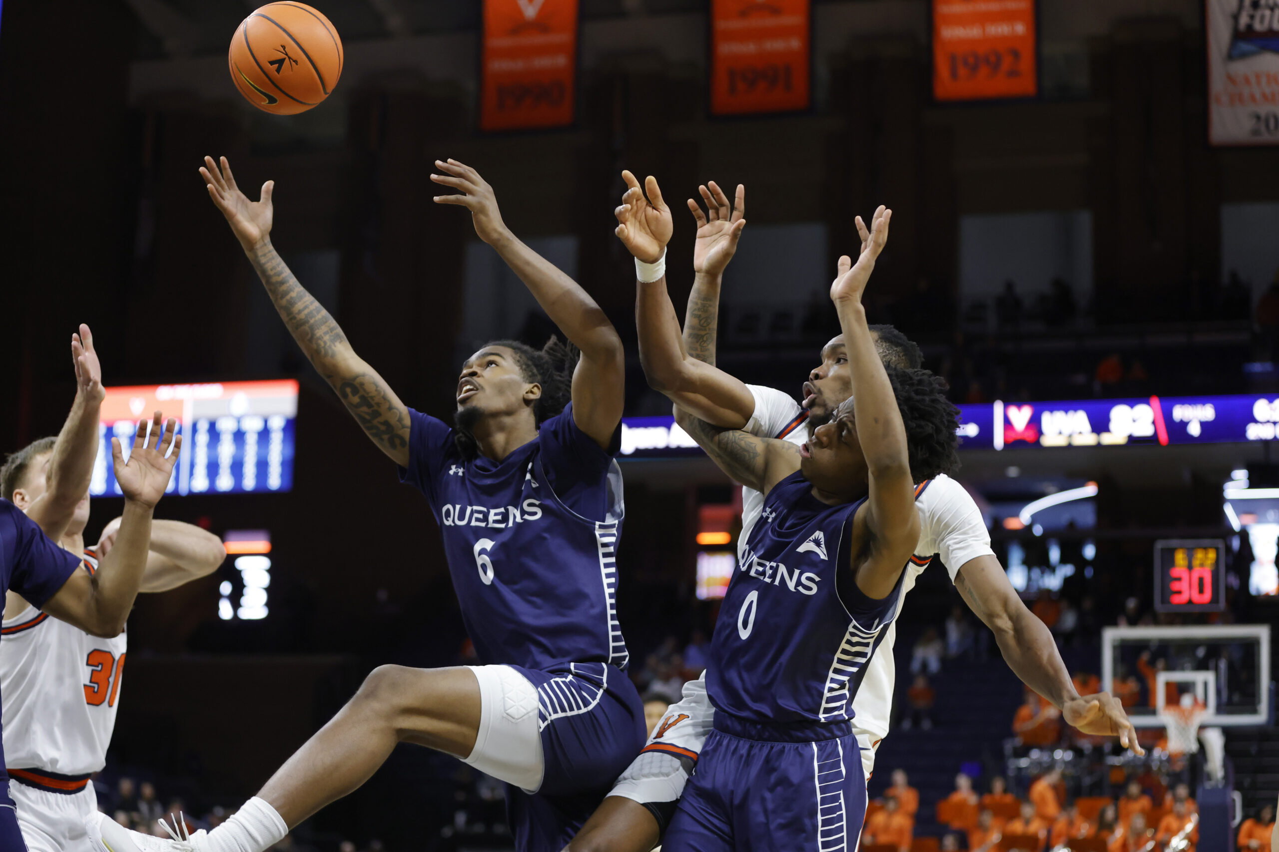 Nov 28, 2025; Charlottesville, Virginia, USA; Queens University of Charlotte Royals forward Avantae Parker (6) and Royals guard Jordan Watford (0) battles for the ball with Virginia Cavaliers center Ugonna Onyenso (33) during the second half at John Paul Jones Arena. Mandatory Credit: Amber Searls-Imagn Images
