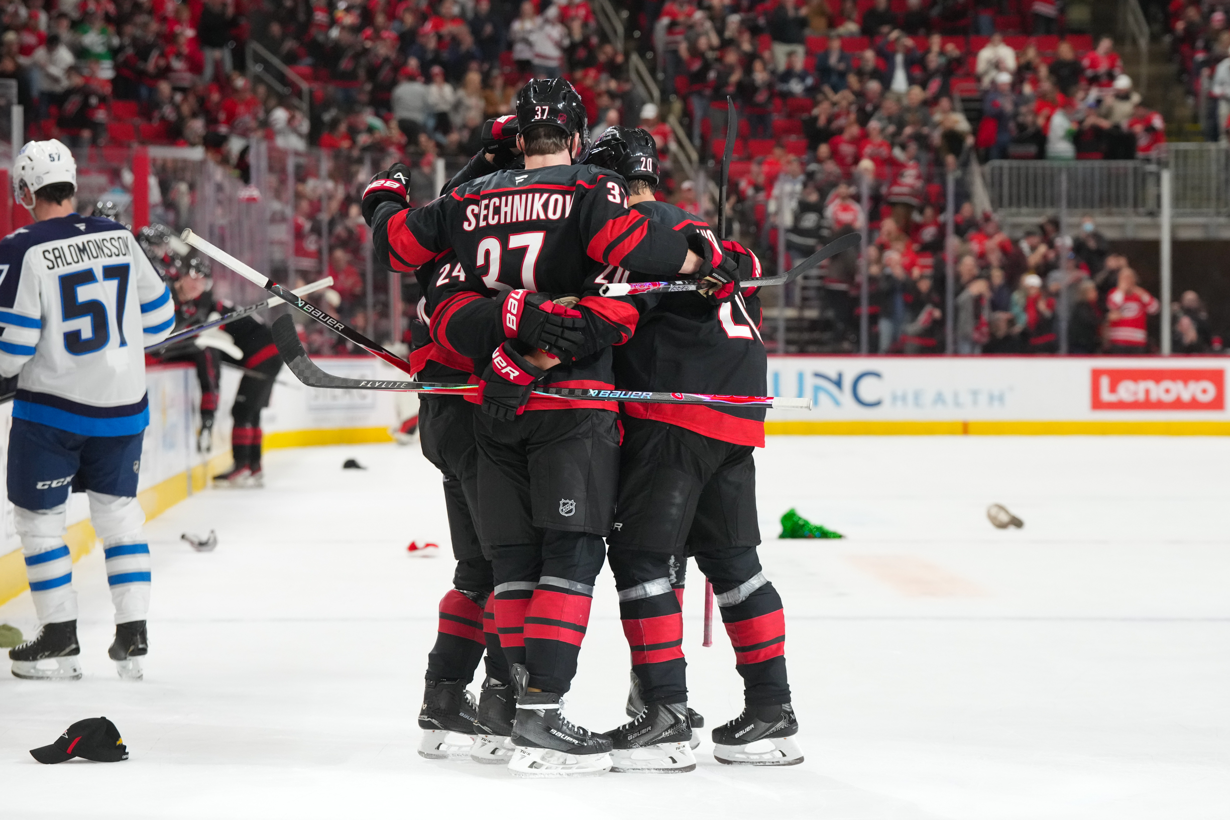 Nov 28, 2025; Raleigh, North Carolina, USA;  Carolina Hurricanes center Seth Jarvis (24) is congratulated by right wing Andrei Svechnikov (37) and  center Sebastian Aho (20) after his empty net hat trick goal against the Winnipeg Jets during the third period at Lenovo Center. Mandatory Credit: James Guillory-Imagn Images