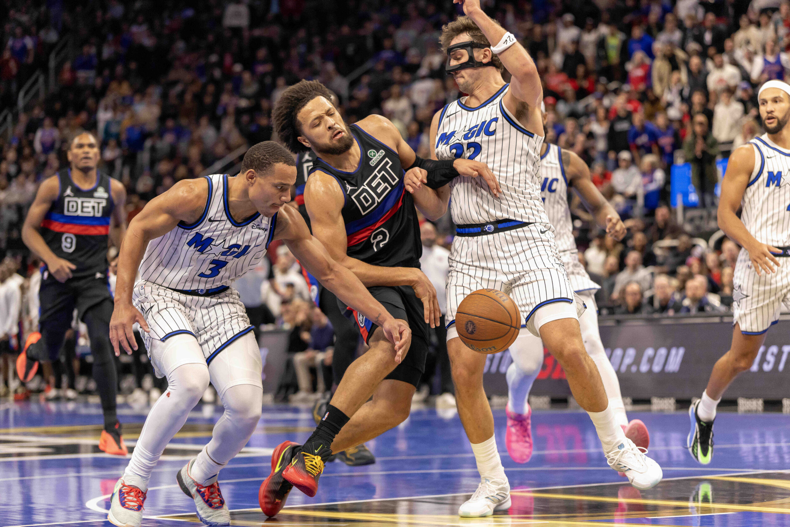Nov 28, 2025; Detroit, Michigan, USA; Orlando Magic forward Franz Wagner (22) and guard Desmond Bane (3) defends against Detroit Pistons guard Cade Cunningham (2) in the second half of the annual in-season NBA Cup tournament at Little Caesars Arena. Mandatory Credit: David Reginek-Imagn Images