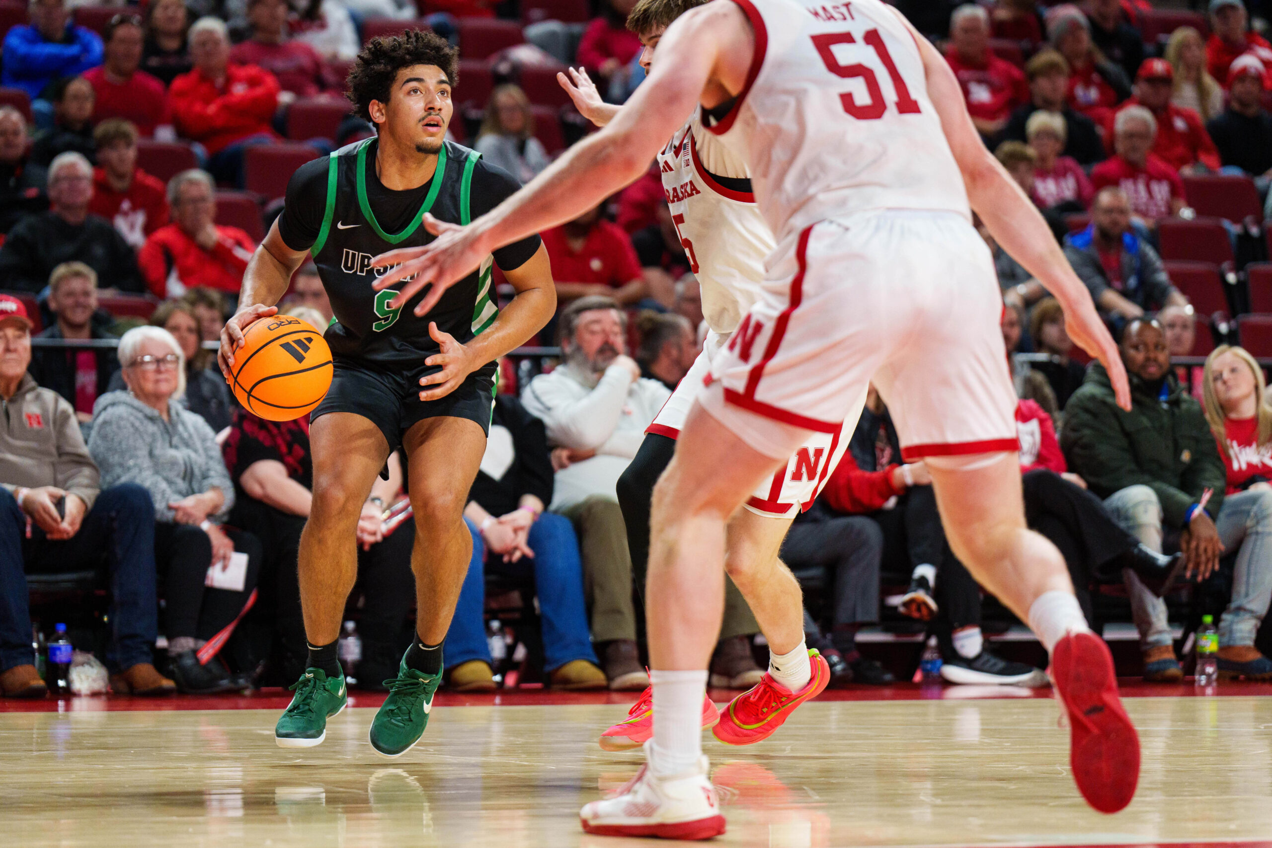 Nov 29, 2025; Lincoln, Nebraska, USA; South Carolina Upstate Spartans guard Mason Bendinger (9) looks to the hoop against Nebraska Cornhuskers forward Braden Frager (5) and forward Rienk Mast (51) during the second half at Pinnacle Bank Arena. Mandatory Credit: Dylan Widger-Imagn Images