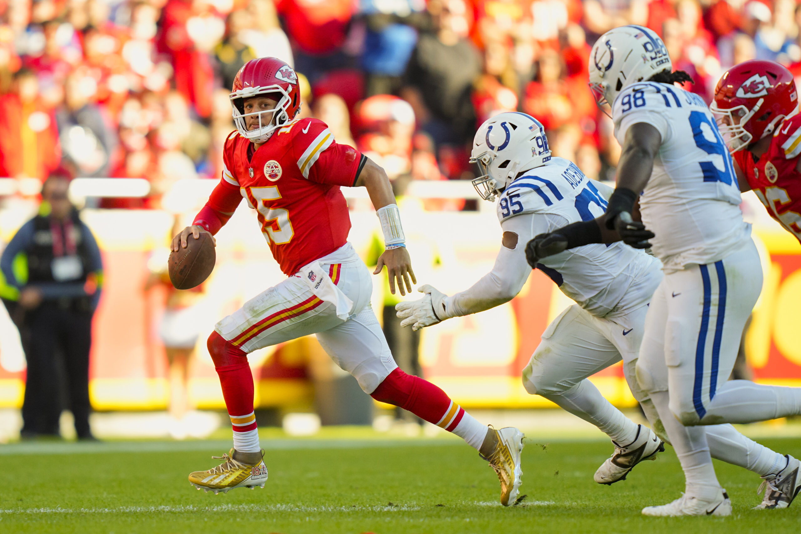 Nov 23, 2025; Kansas City, Missouri, USA; Kansas City Chiefs quarterback Patrick Mahomes (15) scrambles against Indianapolis Colts defensive tackle Adetomiwa Adebawore (95) during the second half at GEHA Field at Arrowhead Stadium. Mandatory Credit: Jay Biggerstaff-Imagn Images
