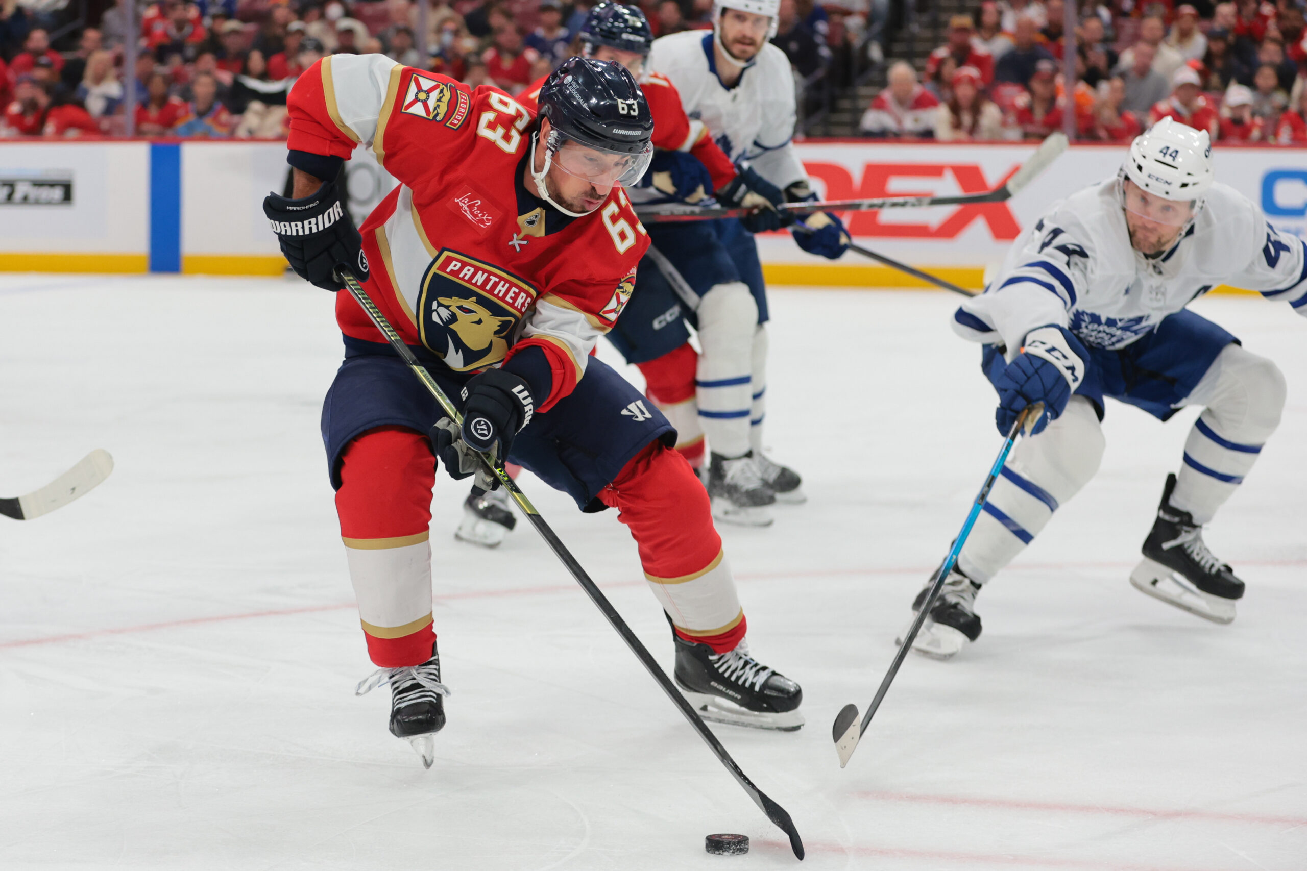 Dec 2, 2025; Sunrise, Florida, USA; Florida Panthers left wing Brad Marchand (63) moves the puck against Toronto Maple Leafs defenseman Morgan Rielly (44) during the third period at Amerant Bank Arena. Mandatory Credit: Sam Navarro-Imagn Images