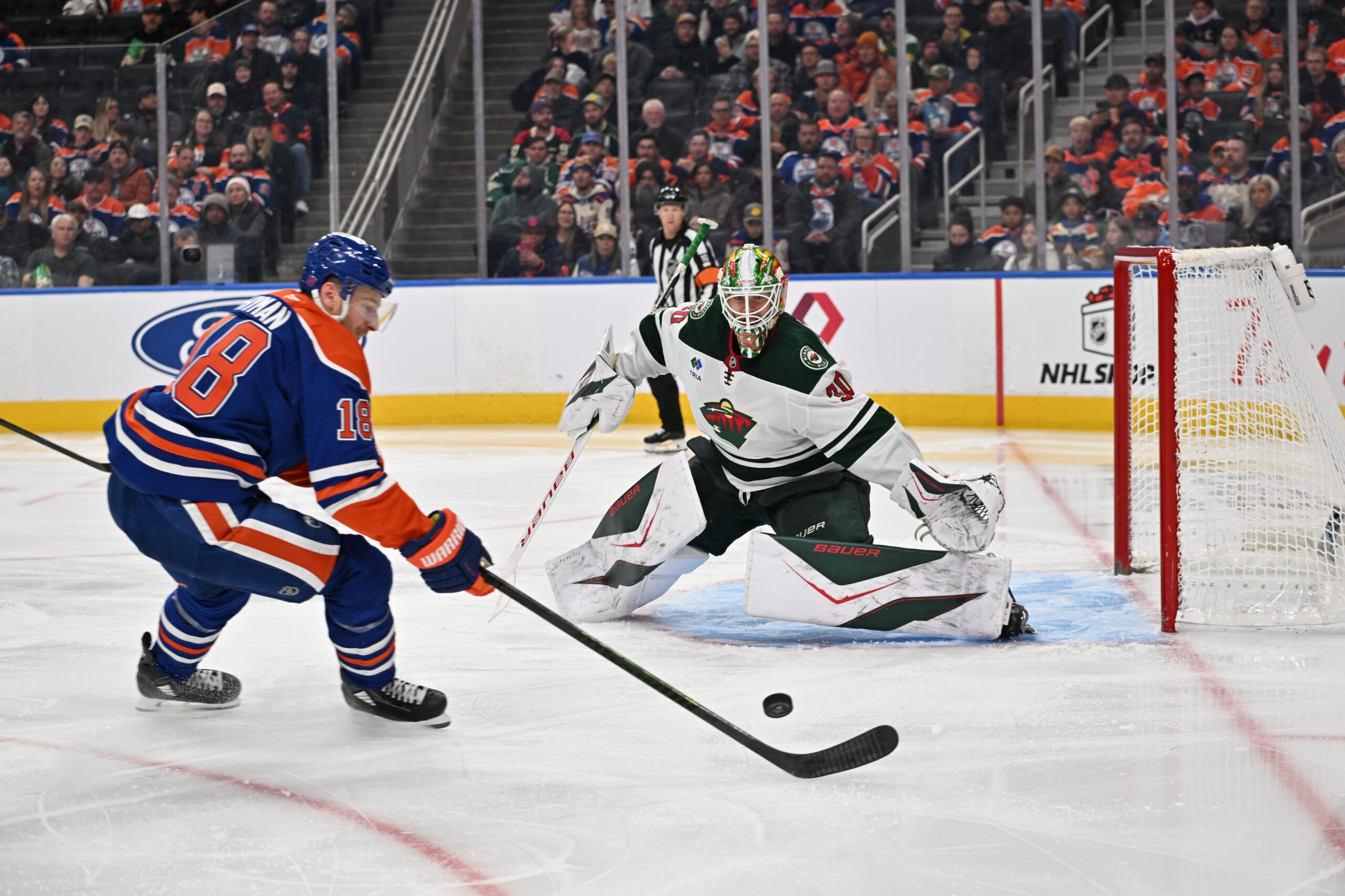 Dec 2, 2025; Edmonton, Alberta, CAN; Edmonton Oilers left wing Zach Hyman (18) goes for the puck in front of Minnesota Wild goalie Jesper Wallstedt (30) during the third period at Rogers Place. Mandatory Credit: Walter Tychnowicz-Imagn Images