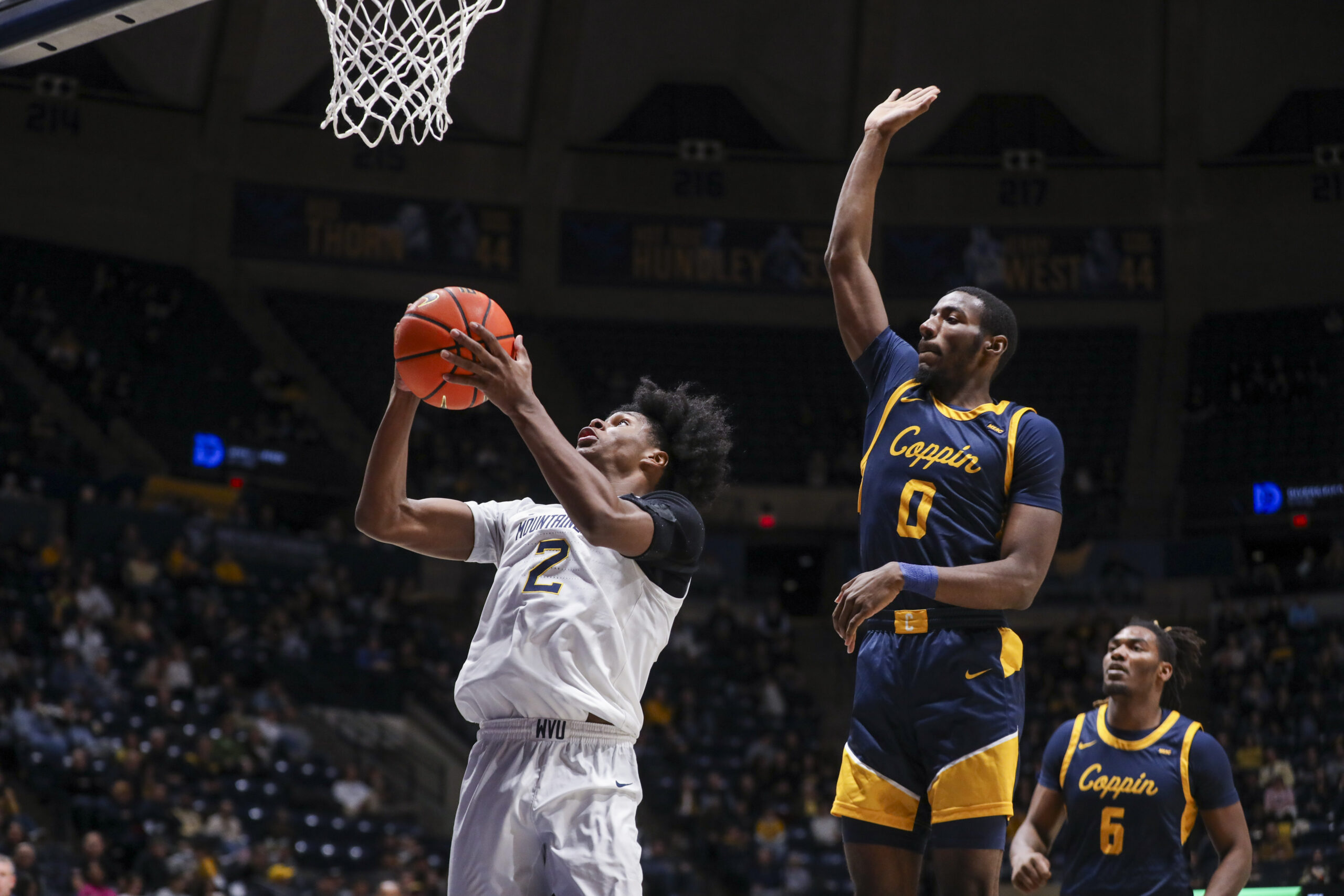 Dec 3, 2025; Morgantown, West Virginia, USA; West Virginia Mountaineers guard Amir Jenkins (2) shoots in the lane while defended by Coppin State Eagles guard Baasil Saunders (0) during the second half at Hope Coliseum. Mandatory Credit: Ben Queen-Imagn Images