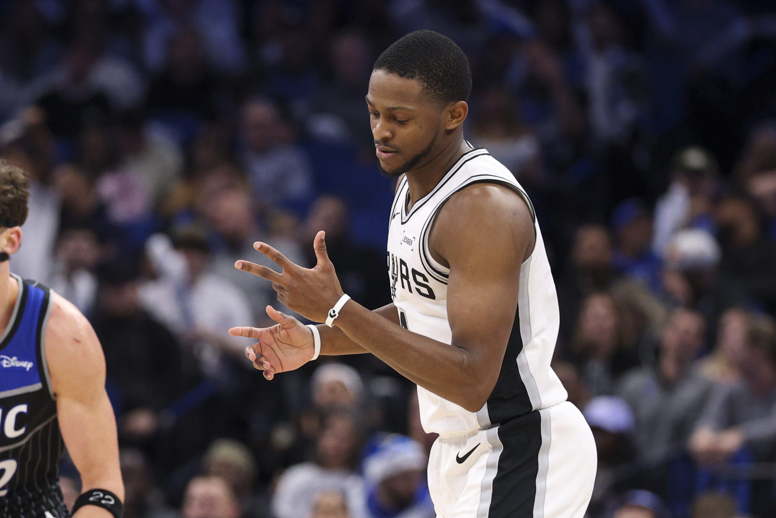 Dec 3, 2025; Orlando, Florida, USA; San Antonio Spurs guard De'Aaron Fox (4) reacts after a three point basket against the Orlando Magic in the fourth quarter at Kia Center. Mandatory Credit: Nathan Ray Seebeck-Imagn Images