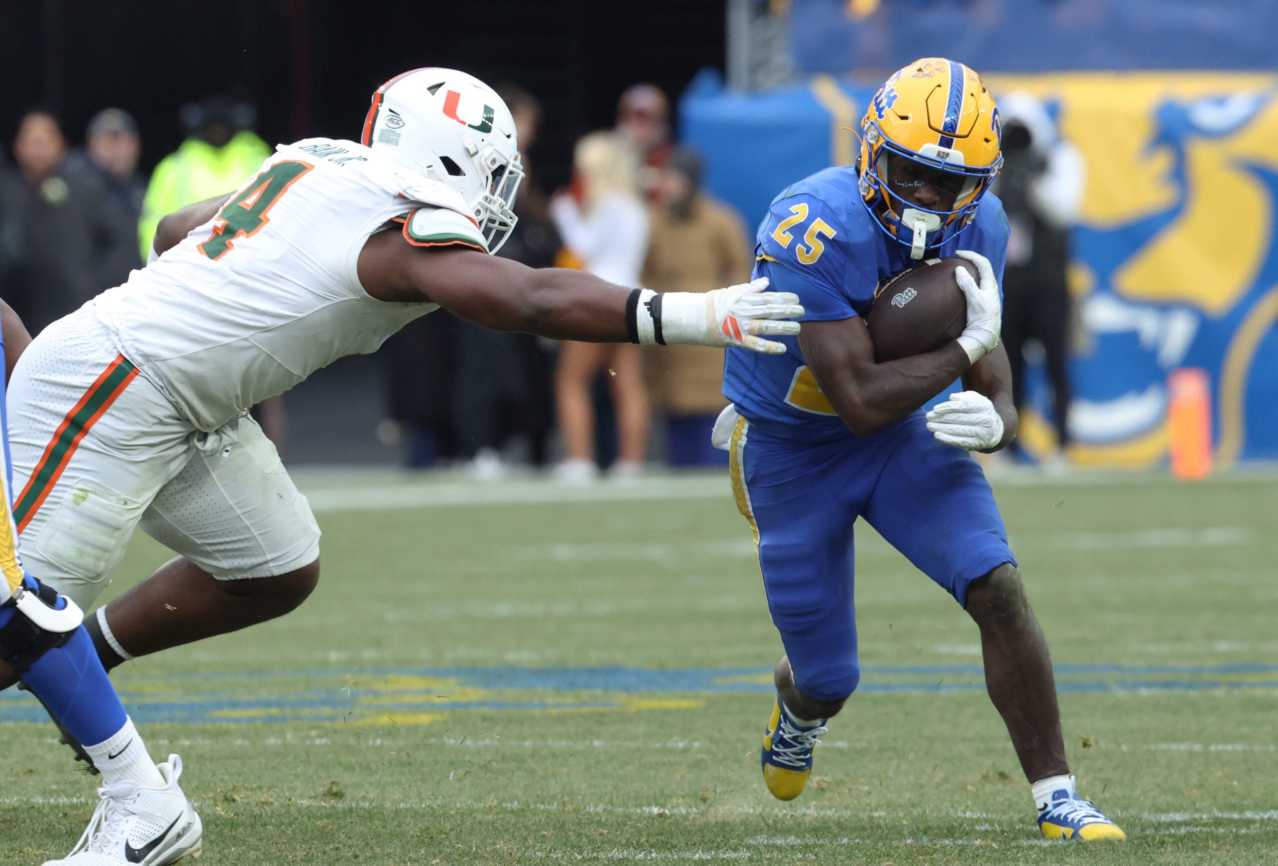 Nov 29, 2025; Pittsburgh, Pennsylvania, USA;  Pittsburgh Panthers running back Ja'Kyrian Turner (25) runs the ball against Miami Hurricanes defensive lineman Rueben Bain Jr. (4) during the third quarter at Acrisure Stadium. Mandatory Credit: Charles LeClaire-Imagn Images